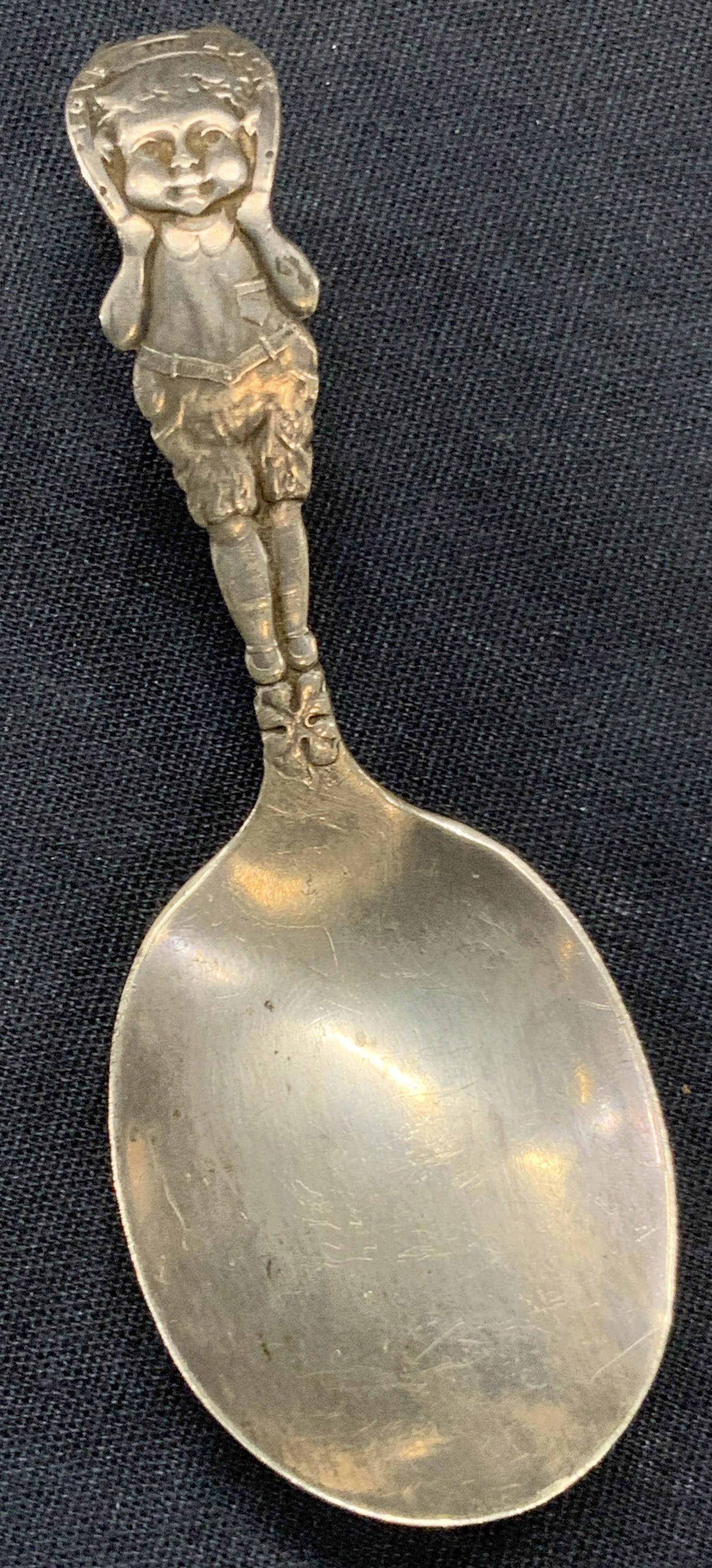 Vtg Sterling Silver Love & Luck Baby Spoon: Vintage baby spoon, sterling silver with a figure of a young boy holding a horse shoe that reads Love and luck on it. Handle of spoon loops Approx 4 inches long. Total weight 0.50 ozt Moderate wearing