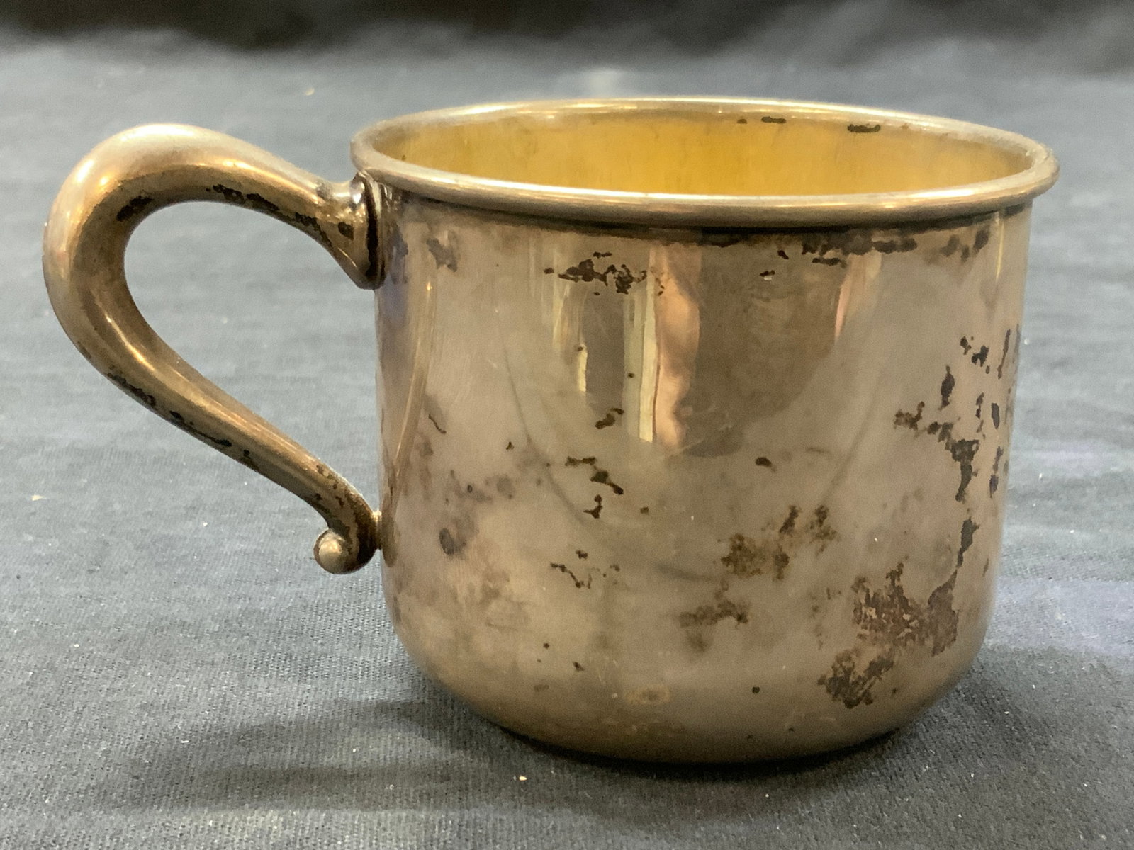 Vtg Sterling Silver Hallmarked Baby Cup: Vintage baby cup, marked WEB, sterling on underside. Interior is a brass toned metal and curved handle. Approx 2.5 inches tall and 3 inch diameter. Evident discoloration and wearing to sterling due to