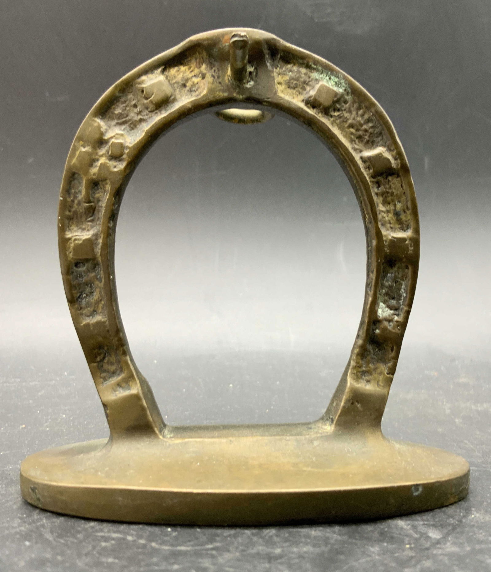 Vintage Brass Horseshoe Tabletop Accessory: A vintage brass horseshoe tabletop accessory. Measures approx 3H x 3.25W in. Patina present. Some surface wear consistent with age, use, and exposure. Collectibles, home decor, tabletop accessories an