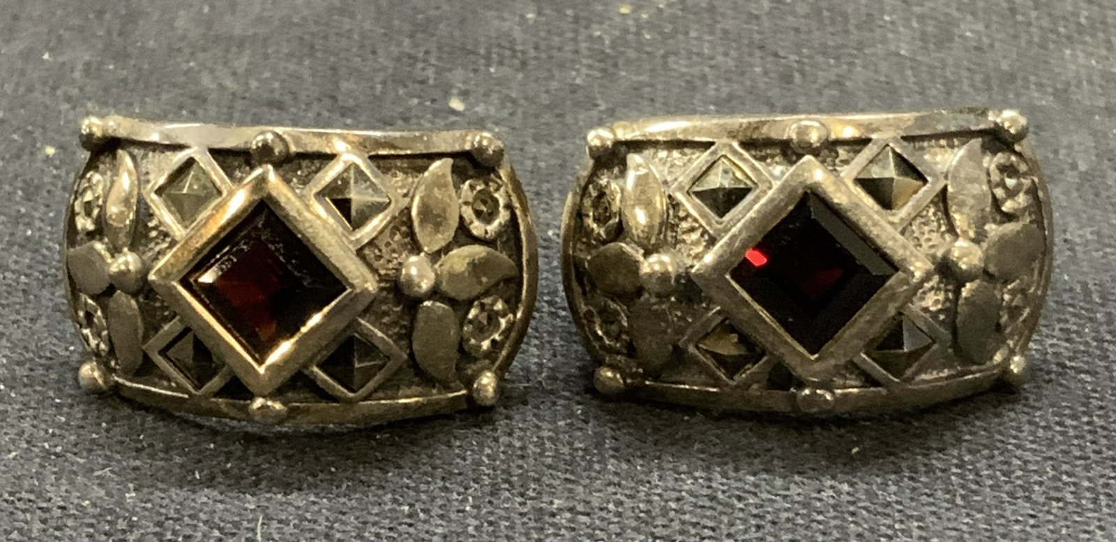 Vintage Sterling Silver Garnet Earrings: Vintage sterling silver clip on earrings with garnet and marcasite decoration. Marked sterling to underside. Measure approx. .75 x .5 inches. Total weight 8.4 grams. Some surface wear including scratc