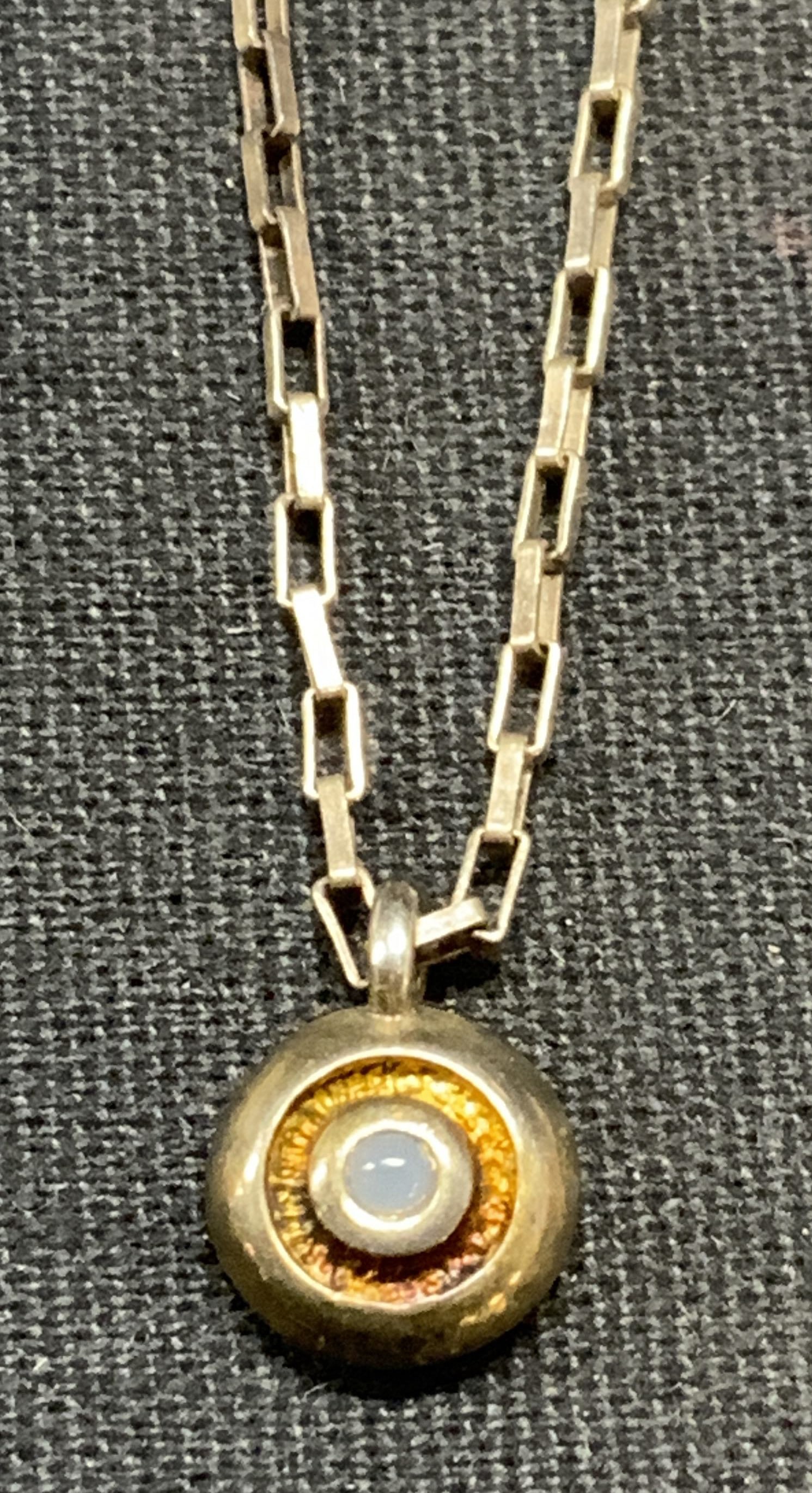 Vintage Sterling Silver Pendant Necklace: Vintage sterling silver necklace with round pendant and blue cabochon. Marked sterling. Drop length approx. 7.5 inches. Total weight 3.4 grams. Some surface wear including scratching observed. Estate 