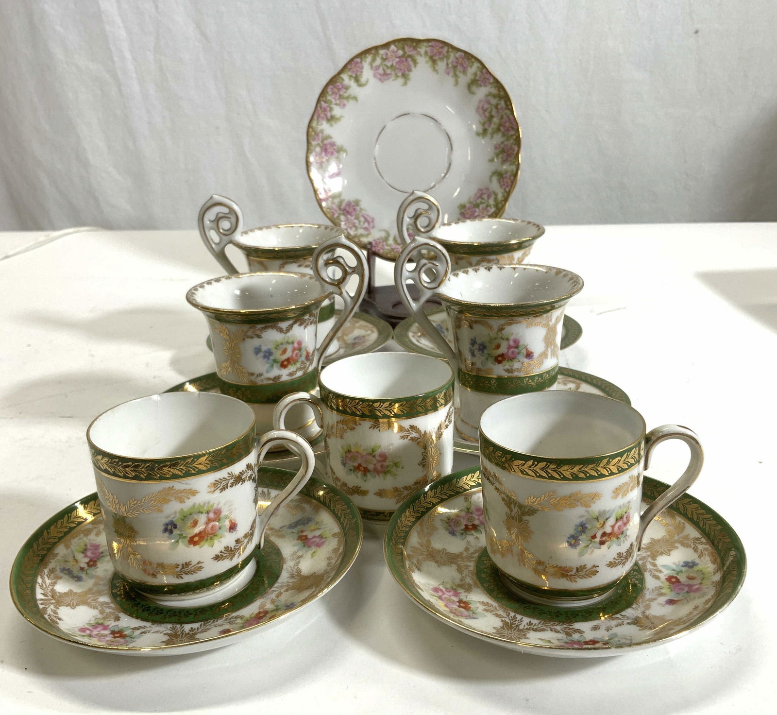 Higgins & Seiter Demitasse Porcelain Set15 Austria: Higgins & Seiter Demitasse Porcelain Set. Made in AUSTRIA. Hand painted Porcelain demitasse cups and tea cups, 2 sizes. 4 of the taller size, 4 in. Ht with handle, 2.5 in. Diameter. 1 cup has a surfac
