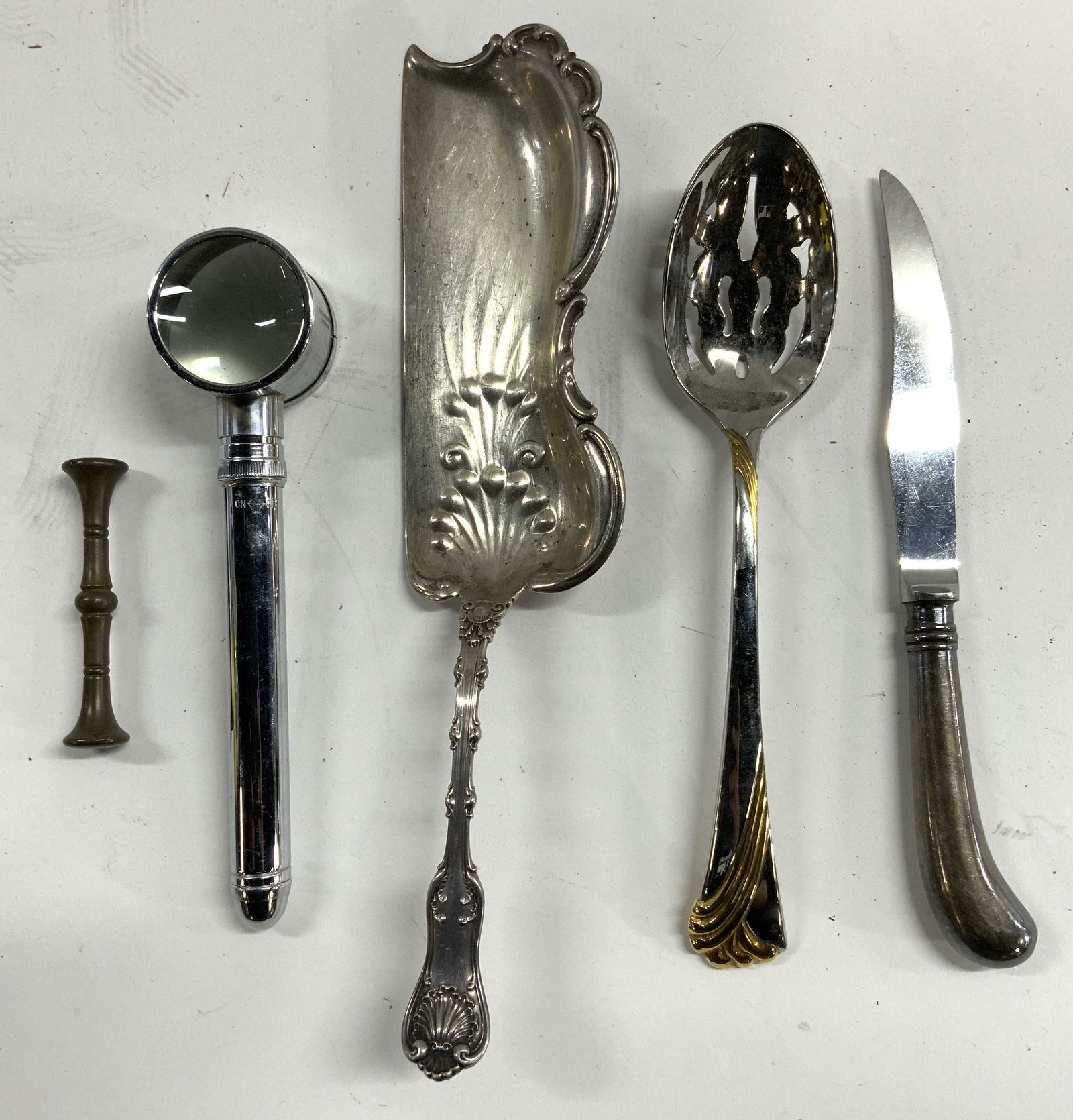 STERLING SILVER Lot 5 Crumb Catcher & More: Lot includes 1 crumb catcher inscribed STERLING. Lot includes 1 crumb catcher, 1 magnifying glass, 1 gilt metal pestle, 1 serving spoon trademarked GORHAM & 1 knife marked VINERS OF SHEFFIELD. Largest