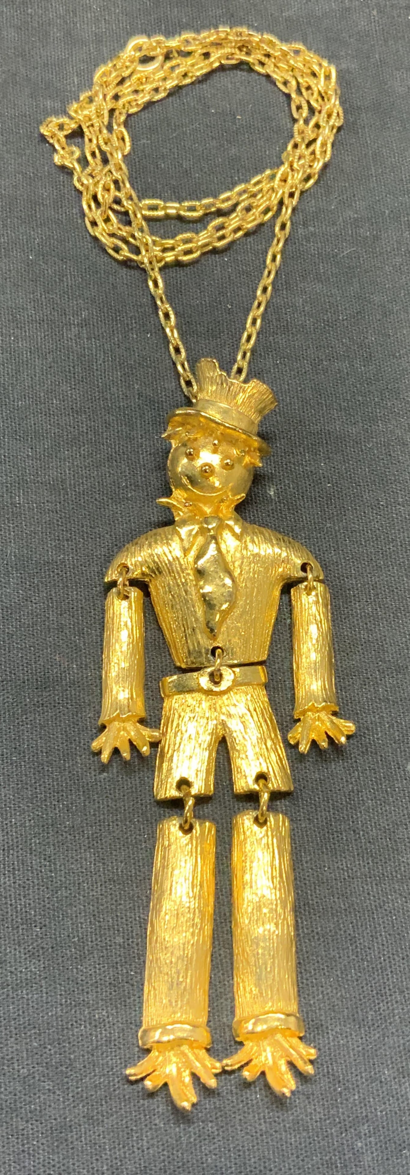 Gold Tone Scarecrow Figural Pendant Necklace: Gold tone scarecrow figural dangling pendant necklace with moving limbs. Drop length approx. 12.5 inches. Pendant measures approx. 4 inches long. Some surface wear including scratching observed. Estat