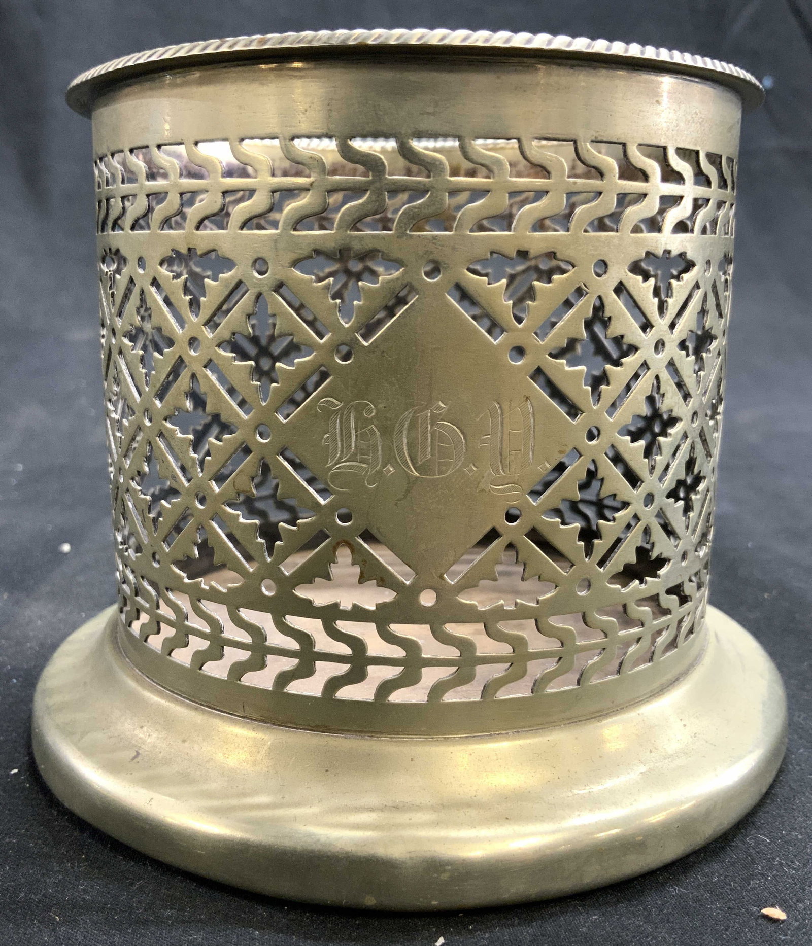HE & CO Monogram Electro Plated Vtg Wine Coaster: Coaster appears to be monogrammed h G Y. Near rim is inscribed H E & CO EP. Coaster is vintage with geometric pattern pierced detail. Piece measures approximately 4 inches tall 4.5 inches wide. Wine c