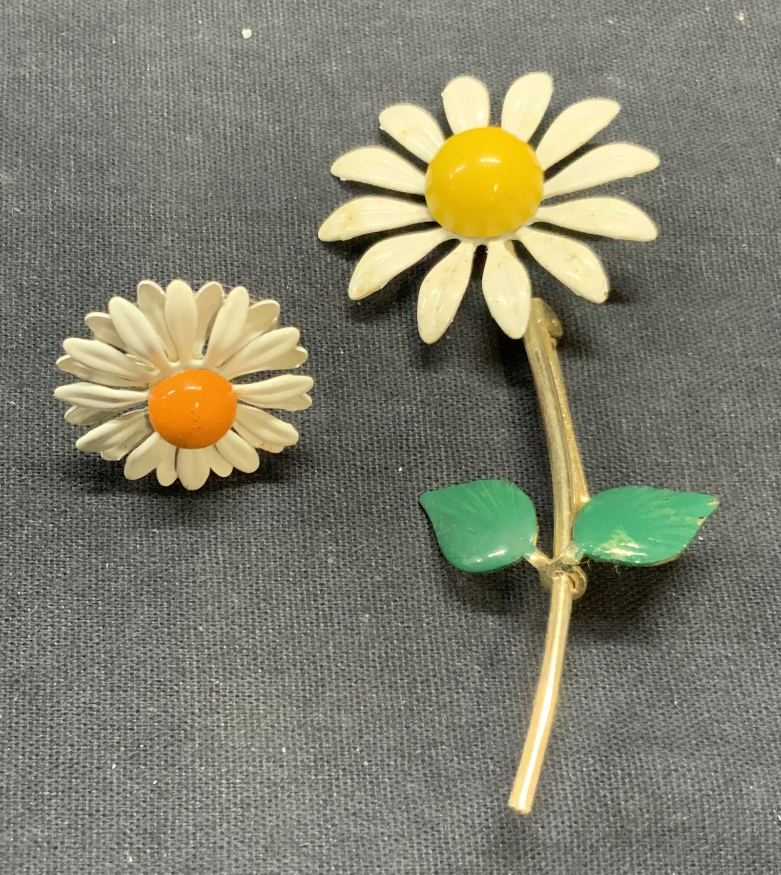 Lot 2 Vintage Daisy Flower Brooch & Ring: Vintage gold tone enameled daisy flower motif brooch. Hinge pin to underside. Measures approx. 3.5 x 1.5 inches. Vintage enameled daisy flower motif ring. Adjustable band. Flower measures approx. 1 in