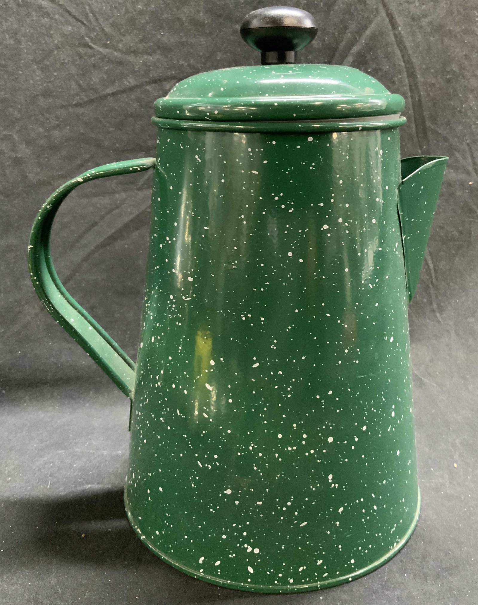 Green Speckled Metal Coffee Pot W Lid: Coffee pot is green with white toned speckled detail. Piece is metal. Coffee pot includes lid. Lid handle is black toned with knob form. Piece measures approximately 9 inches tall 7.25 inches deep 5.5