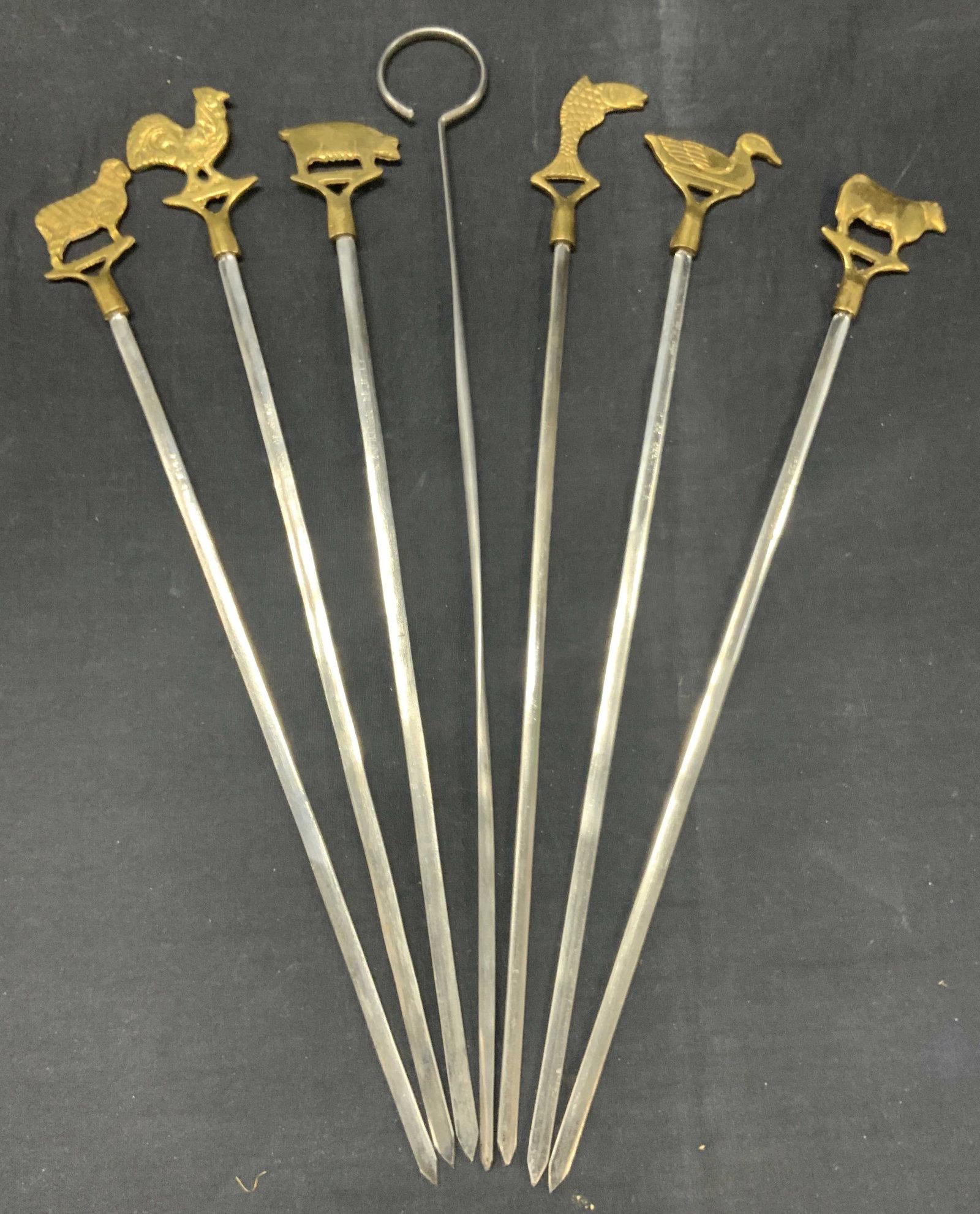 7 Vintage Brass & Steel Animal Skewers: Set of 7 vintage brass and steel skewers with brass animal ornaments on ends and 1 skewer with a loop Approx 16 and 17 inches long. Moderate wearing to steel and brass ware. Brass and metal skewers, v