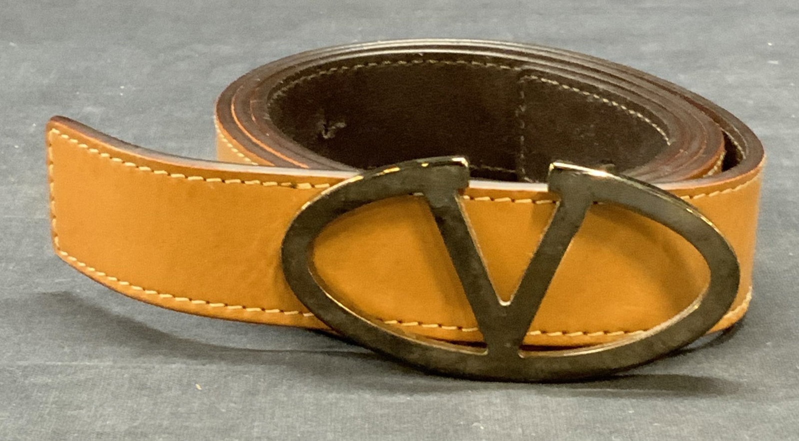 Valentino Garavani Tan Leather Belt, Italy: Valentino Garavani tan leather belt with silver tone V belt buckle. Signed to interior. Size 42. Made in Italy. Some wear to leather and buckle including scratching observed. Valentino Garavani, Valen
