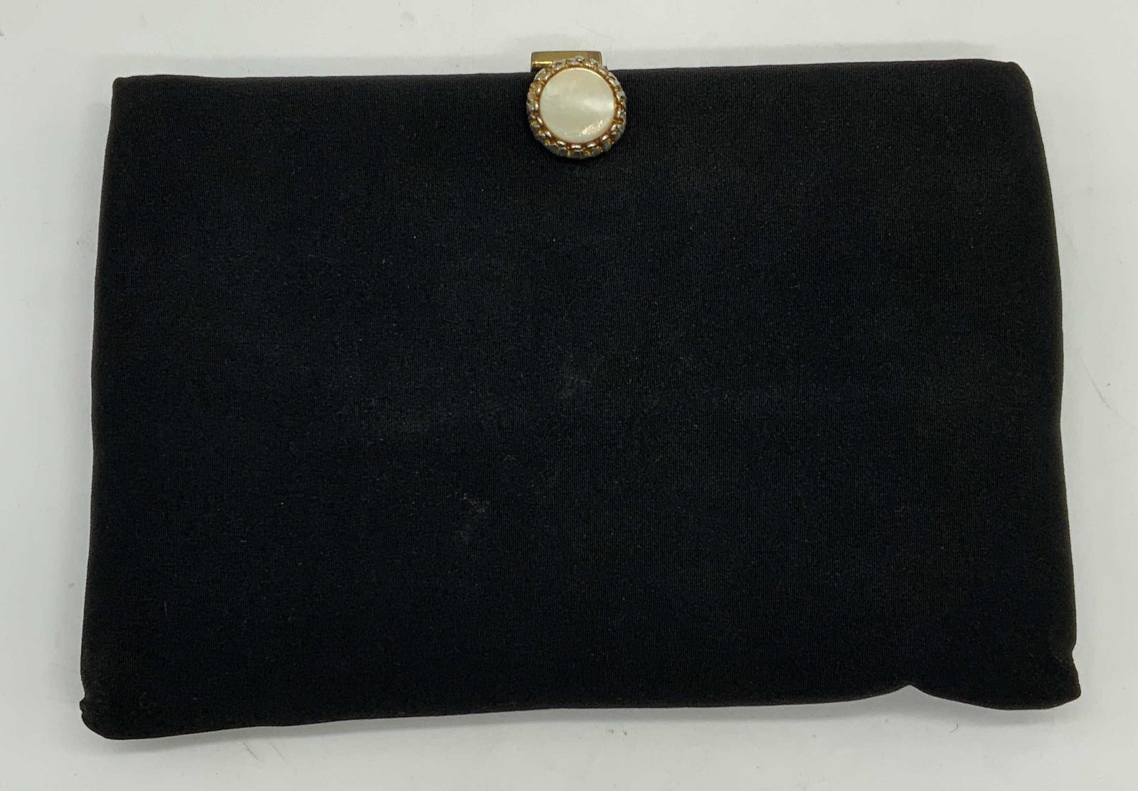 Vintage Black Mother of Pearl Clutch: Vintage black fabric clutch with hidden chain and mother of pearl clasp. Signed illegibly to interior. Measures approx. 6 x 9 inches. Some wear to material consistent with exposure. Ladies clutch, lad