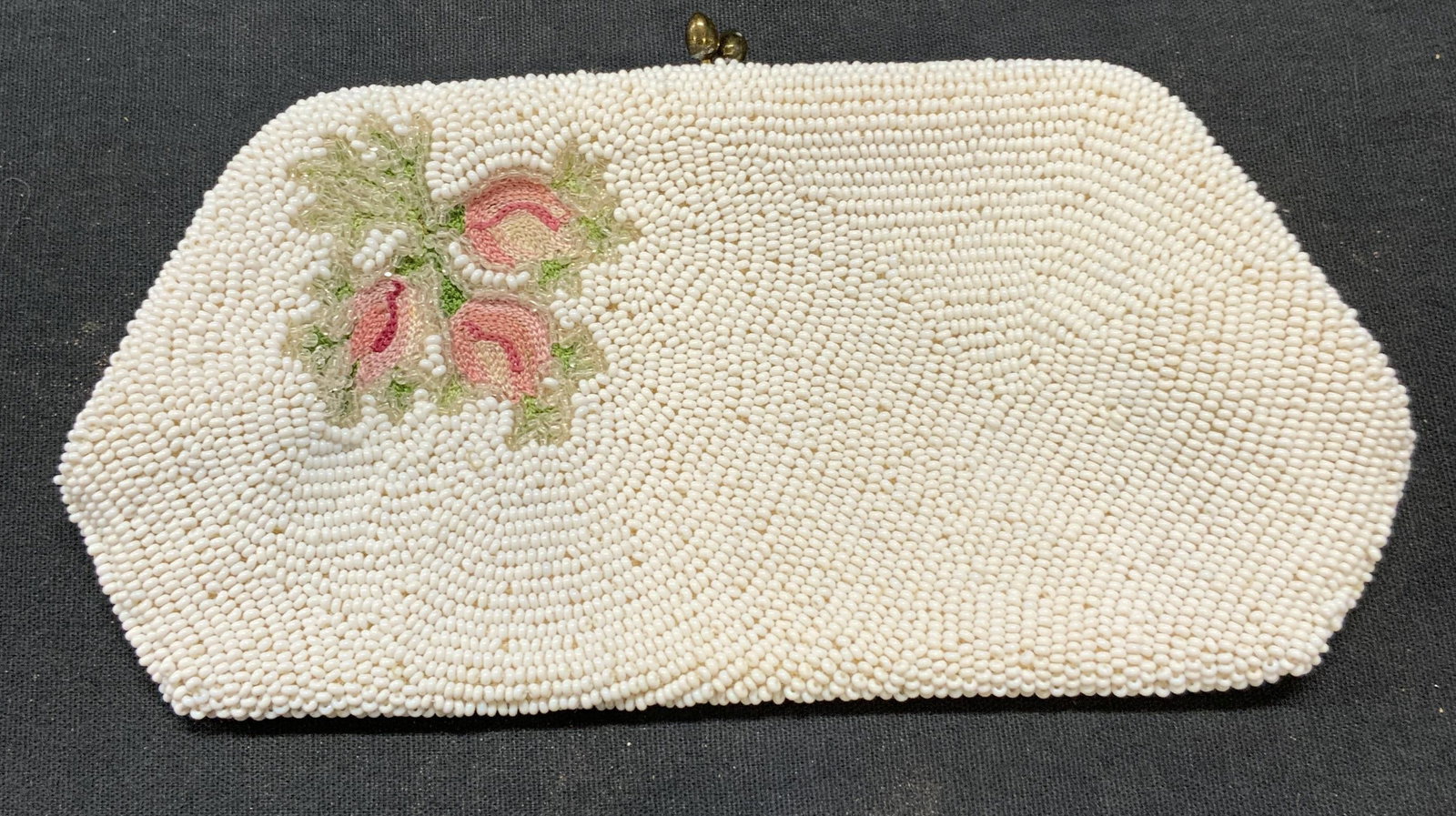 Vintage Saks Fifth Ave Beaded Clutch, Belgium: Vintage Saks Fifth Avenue white beaded clutch with floral motif. Signed to interior. Made in Belgium. Measures approx. 3.25 x 6.75 inches. Some wear to material including scratching observed. Saks fif
