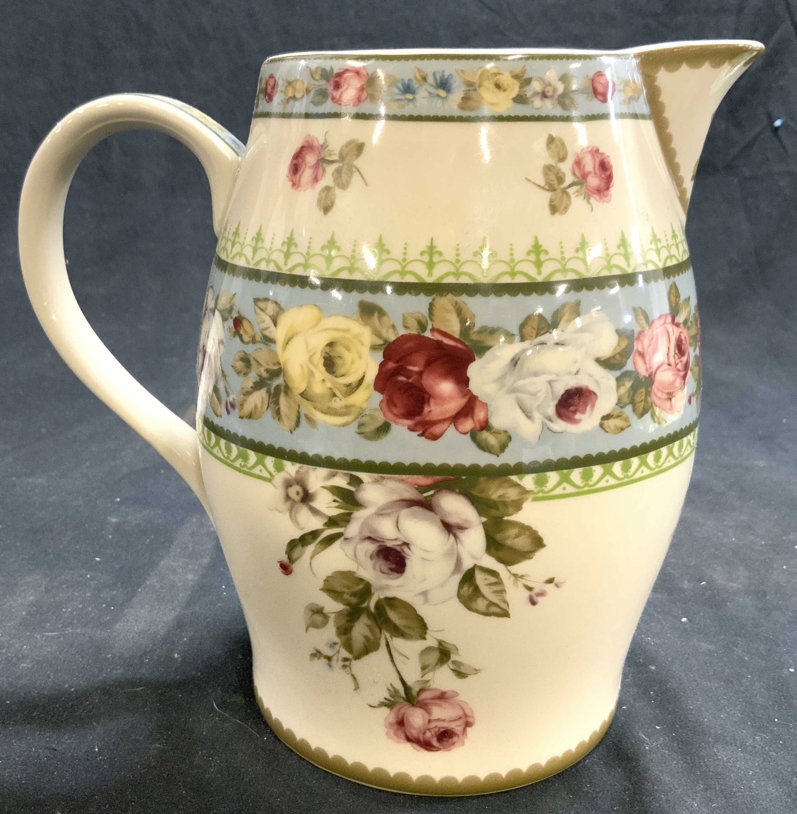 Trademarked Ironstone Floral Pitcher Vessel: Underside has trademark with lion crown and ribbon detail. Pitcher appears to be ironstone possibly porcelain. Piece has intricate multi toned floral, leaf and geometric detail. Pitcher has half heart