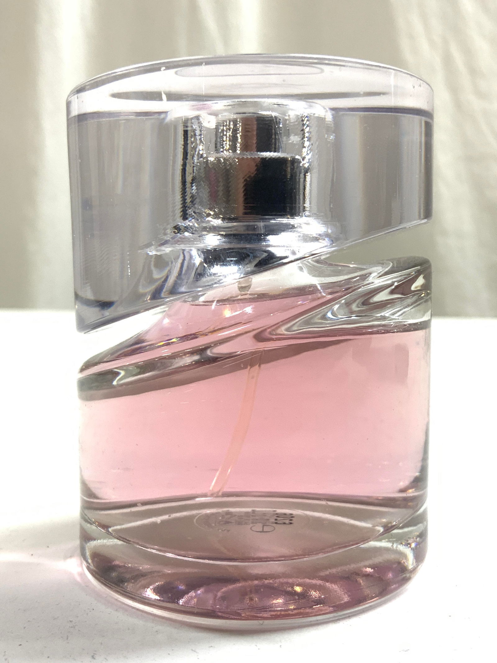 HUGO BOSS FEMME Eau De Parfum 1.6 Oz: Atomizer Collar reads HUGO BOSS. Bottle is mostly full. Bottle is glass underside reads 1.6 oz 50 ml. Liquid is pink toned. Batch code on underside reads 6206. Bottle is glass, cap appears to be acryl