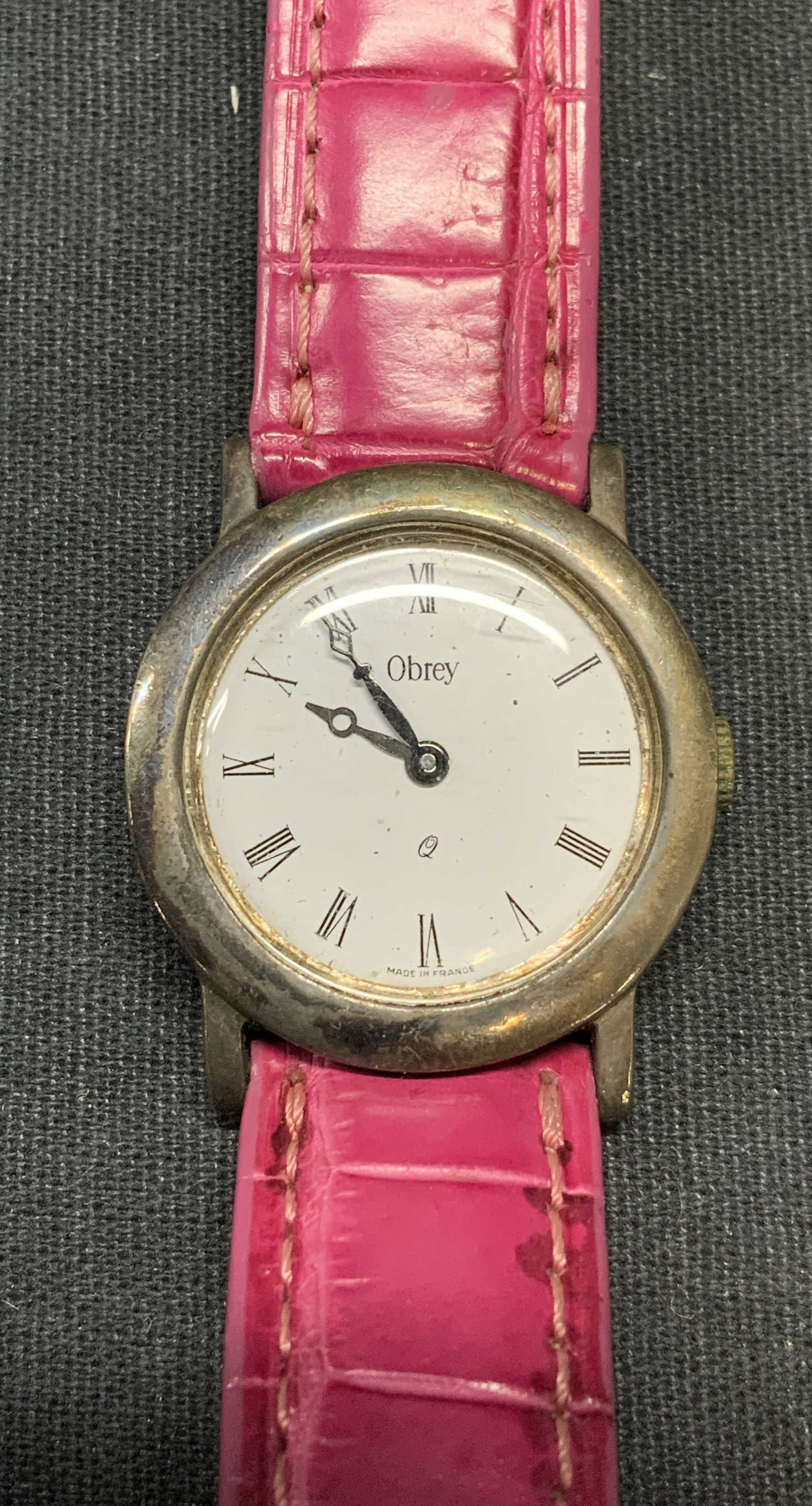 Obrey Paris Sterling Silver Watch, France: Obrey Paris sterling silver watch with magenta leather strap. Signed on watch face. Marked solid silver. Made in France. Measures approx. 7.5 inches long. Some surface wear including scratching observ