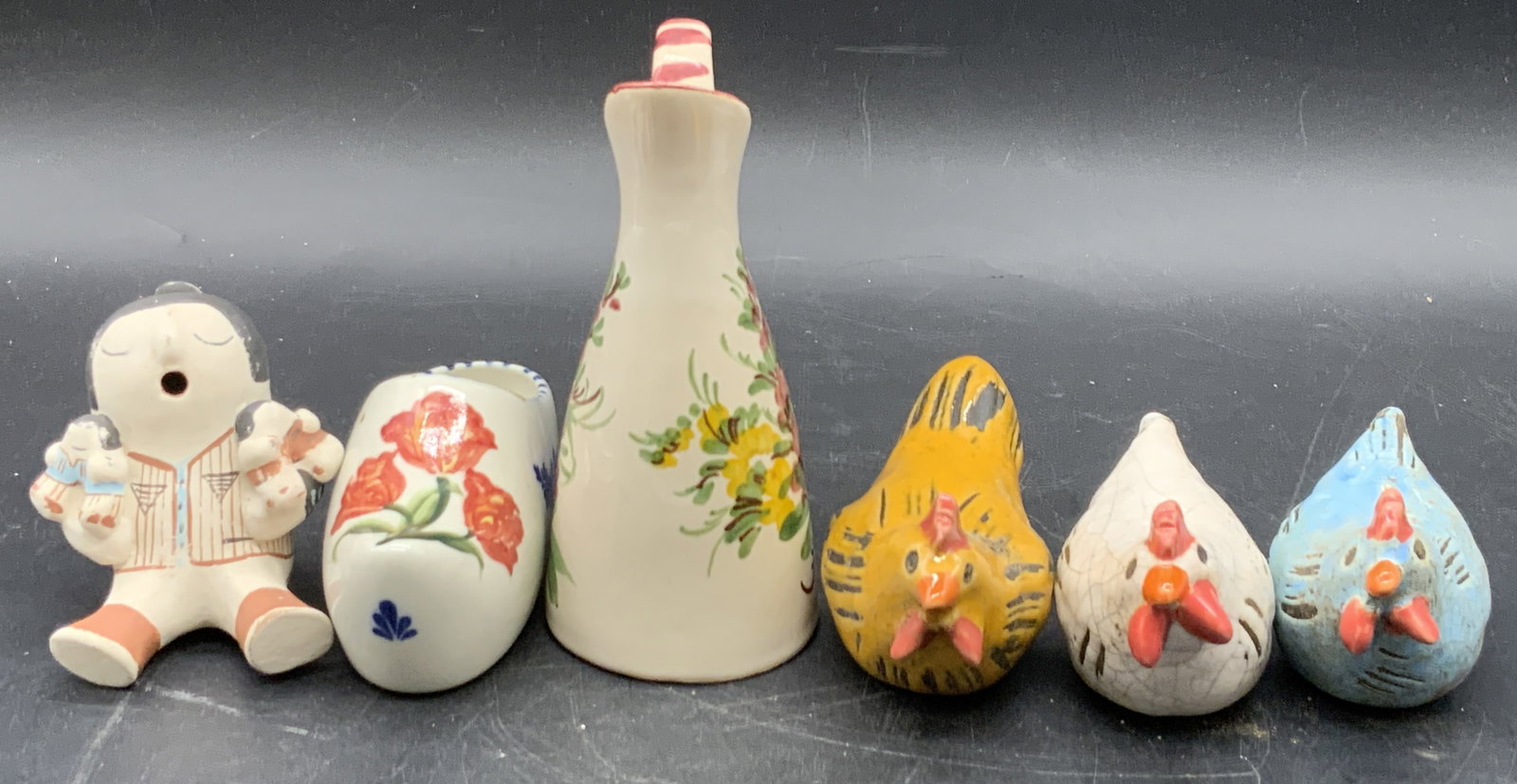 Lot 6 Ceramic & Pottery Figurals, Chickens & More: Six ceramic or pottery figurals. Figures include chickens, a shoe, a creamer, and a figure holding children in their arms. Some undersides are signed: DELFT HANDPAINTED DELFLEUR HOLLAND, ULMER KERAMIK