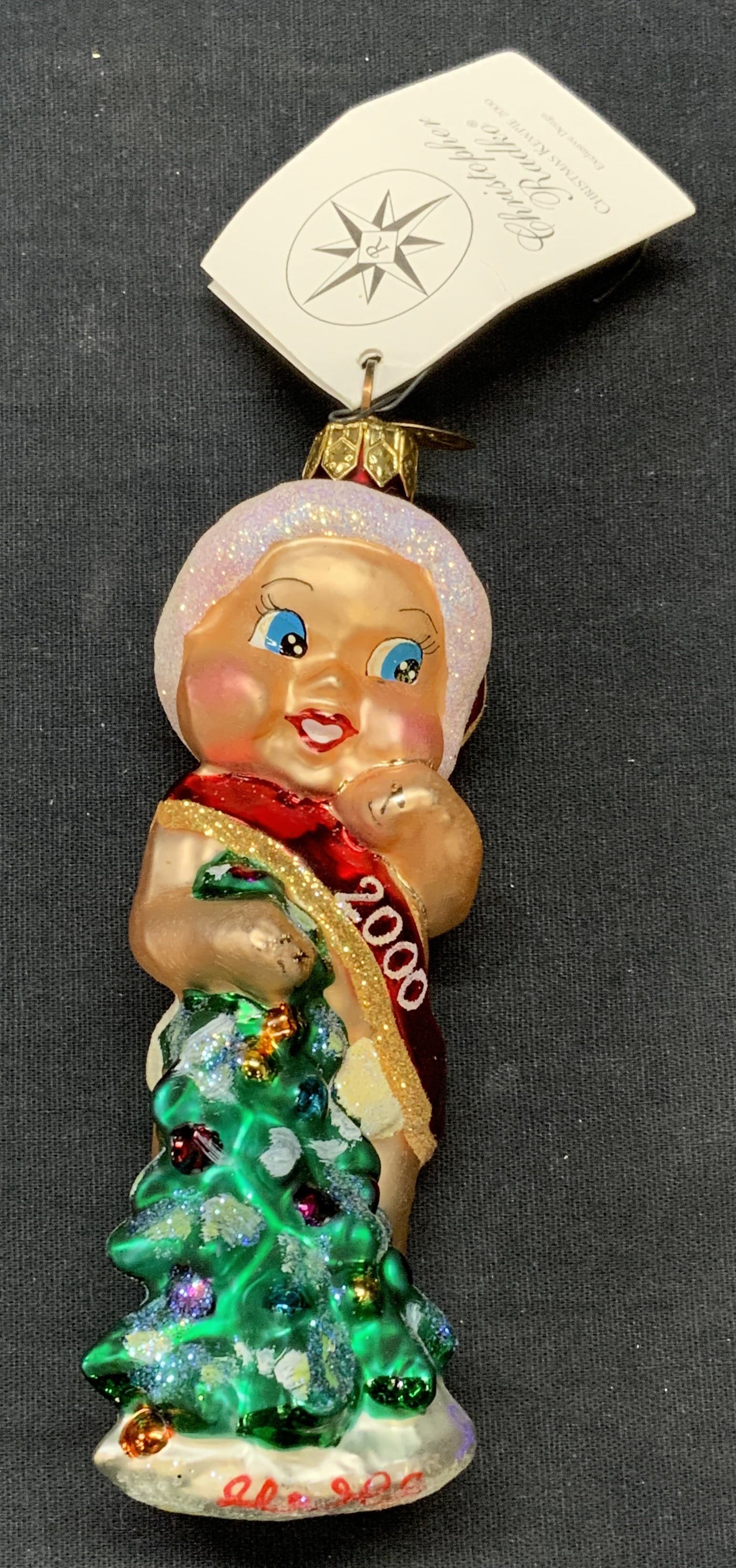Christopher RADKO Glass Baby Ornament, 2000: Christopher RADKO Christmas Kewpie glass baby motif ornament. Produced 2000. Measures approx. 5 inches long. Includes original box. Some surface wear including scratching observed. Christopher RADKO, 