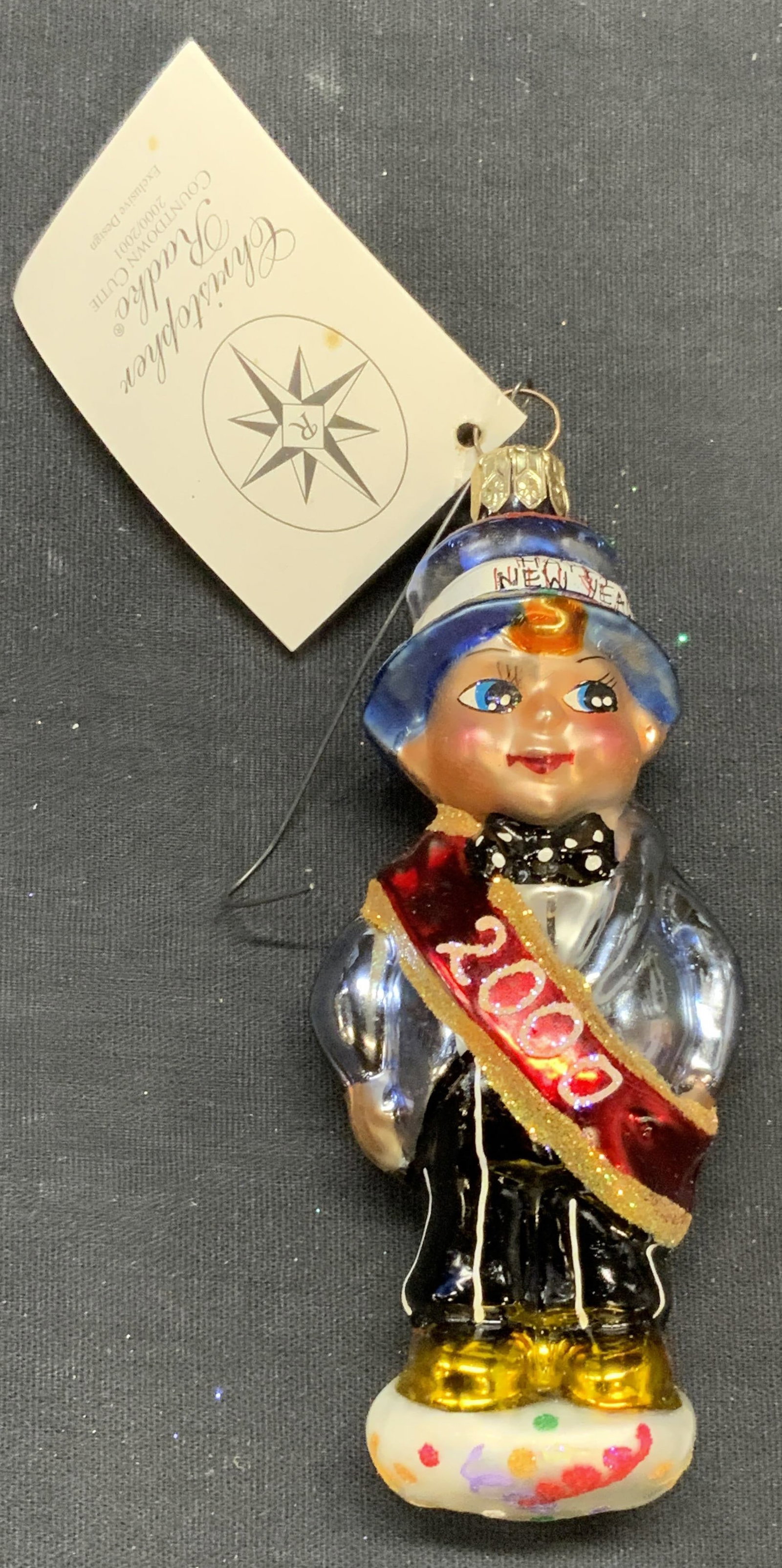 Christopher RADKO New Years Ornament, 2000: Christopher RADKO Countdown Cutie glass baby motif ornament. Produced 2000/2001. Measures approx. 4.5 inches long. Some surface wear including scratching observed. Christopher RADKO, Christopher RADKO