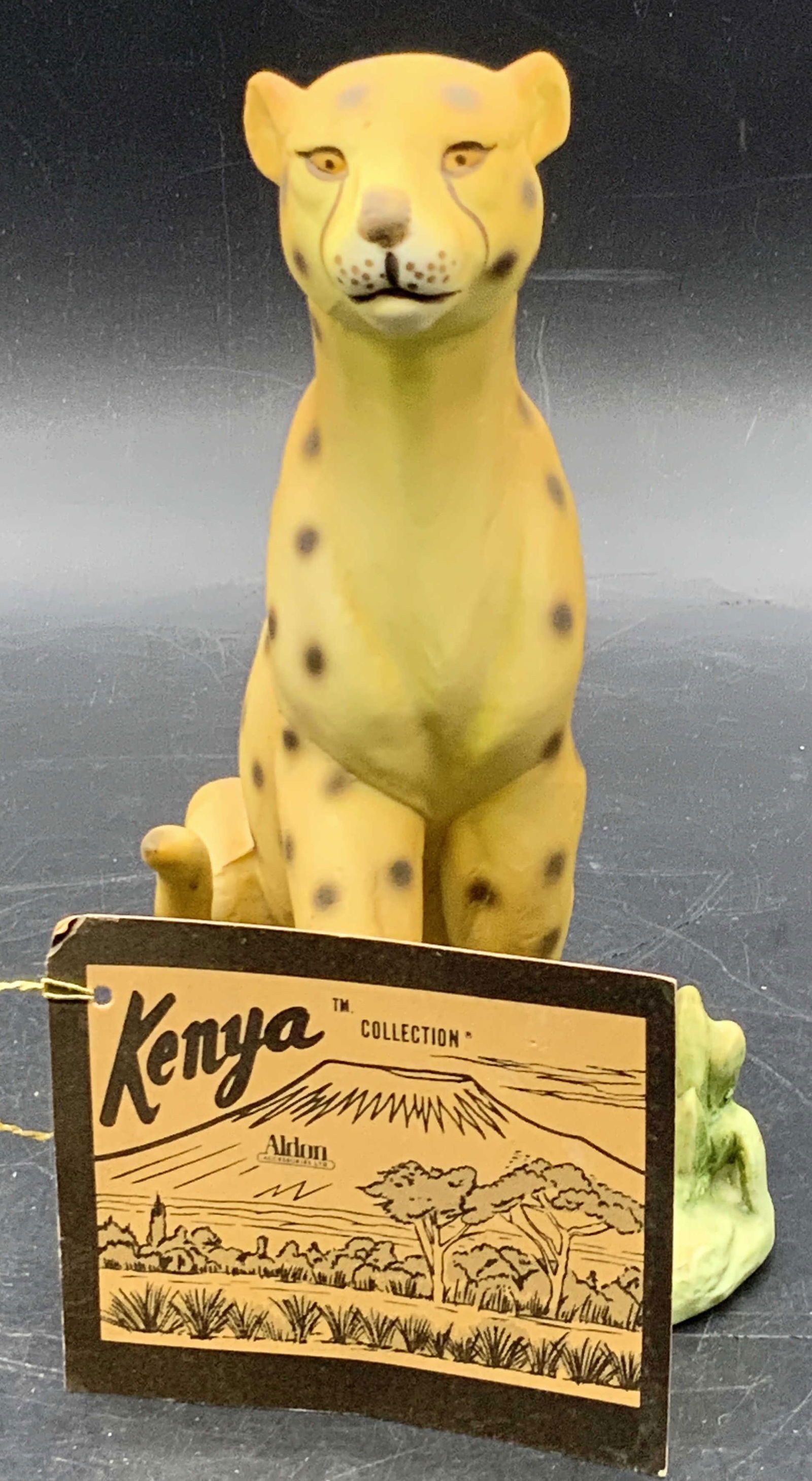 ALDON Kenya Collection Bisque Porc Leopard Figural: A vintage bisque porcelain leopard figural with its original tag. Tag reads ALDON, The Kenya Collection. Underside of leopard is signed. Two stickers to underside, one partial sticker. Piece measures