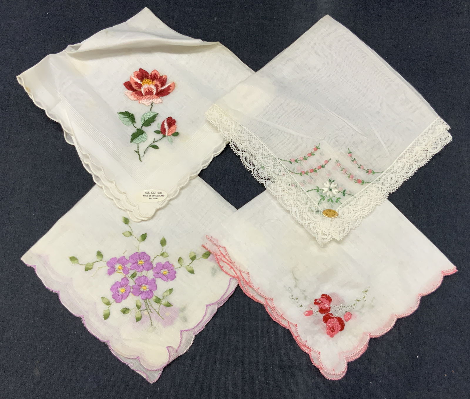 Lot 4 Embroidered Floral & Lace Handkerchiefs: Lot of 4 embroidered handkerchiefs each with flowers embroidered on corners and 2 marked made in Switzerland and another marked all Cotton. Largest being 11 x 11 inches Moderate blemishes and wearing