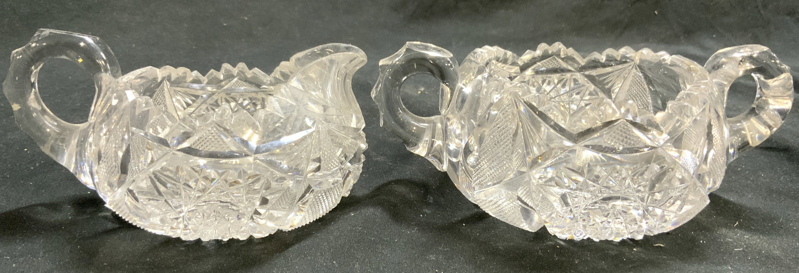 Lot 2 Cut Crystal Sugar & Creamer Dishes: Lot includes 1 creamer and 1 sugar dish. Each piece is crystal. Both have pointed toothed rims and intricate geometric cut detail. Sugar dish measures approximately 6.5 inches wide 4 inches deep 2.5 i