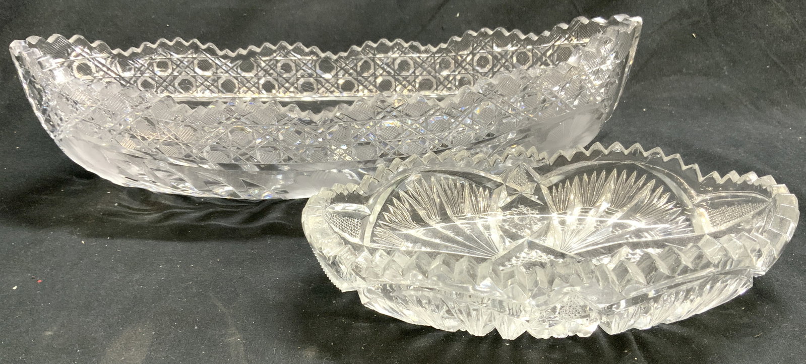 Lot 2 Toothed Rim Crystal Serving Dishes Vessels: Lot includes 2 vessels. Each appear to be crystal. Serving dishes each have toothed rims. Each piece has intricate geometric, floral and leaf cut detail. Largest piece in lot measures approximately 12