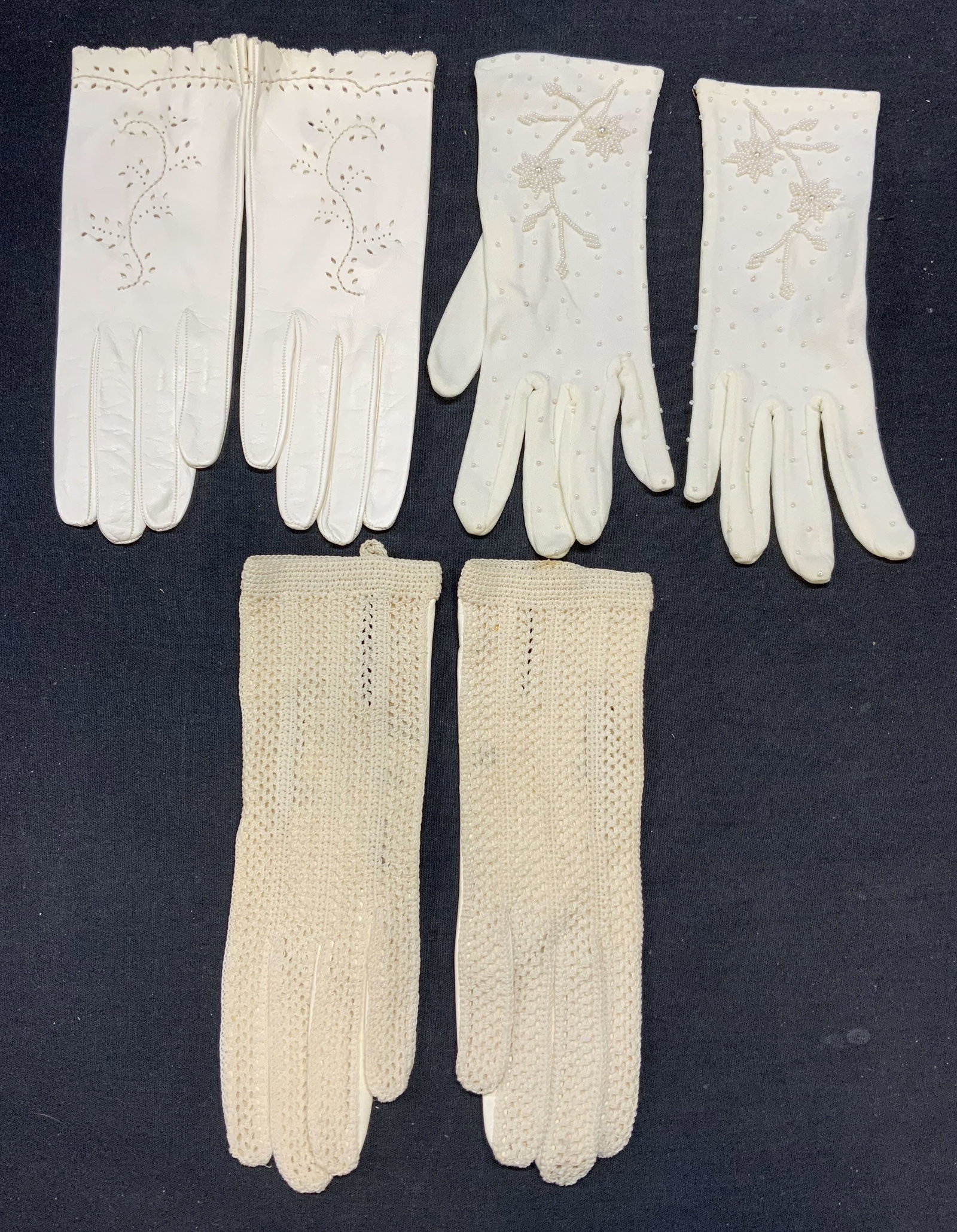 Lot 3 Vintage White Leather & Cotton Gloves: Lot of 3 pairs of white gloves. 1 pair leather, made in Italy. 1 pair leather and knit cotton. 1 pair nylon with faux pearl beading. All pairs measure approx. 8.75 inches long. One pair new without ta