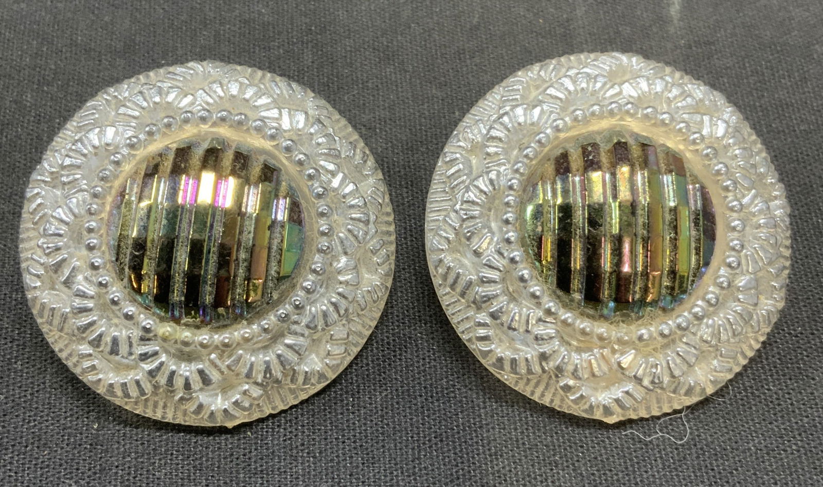 Iridescent Embossed Disc Earrings: White and silver tone iridescent embossed lucite disc earrings. Clip on backing. Measure approx. 1.75 inches diameter. Some scratching observed. Estate jewelry, costume jewelry, cocktail jewelry, fash