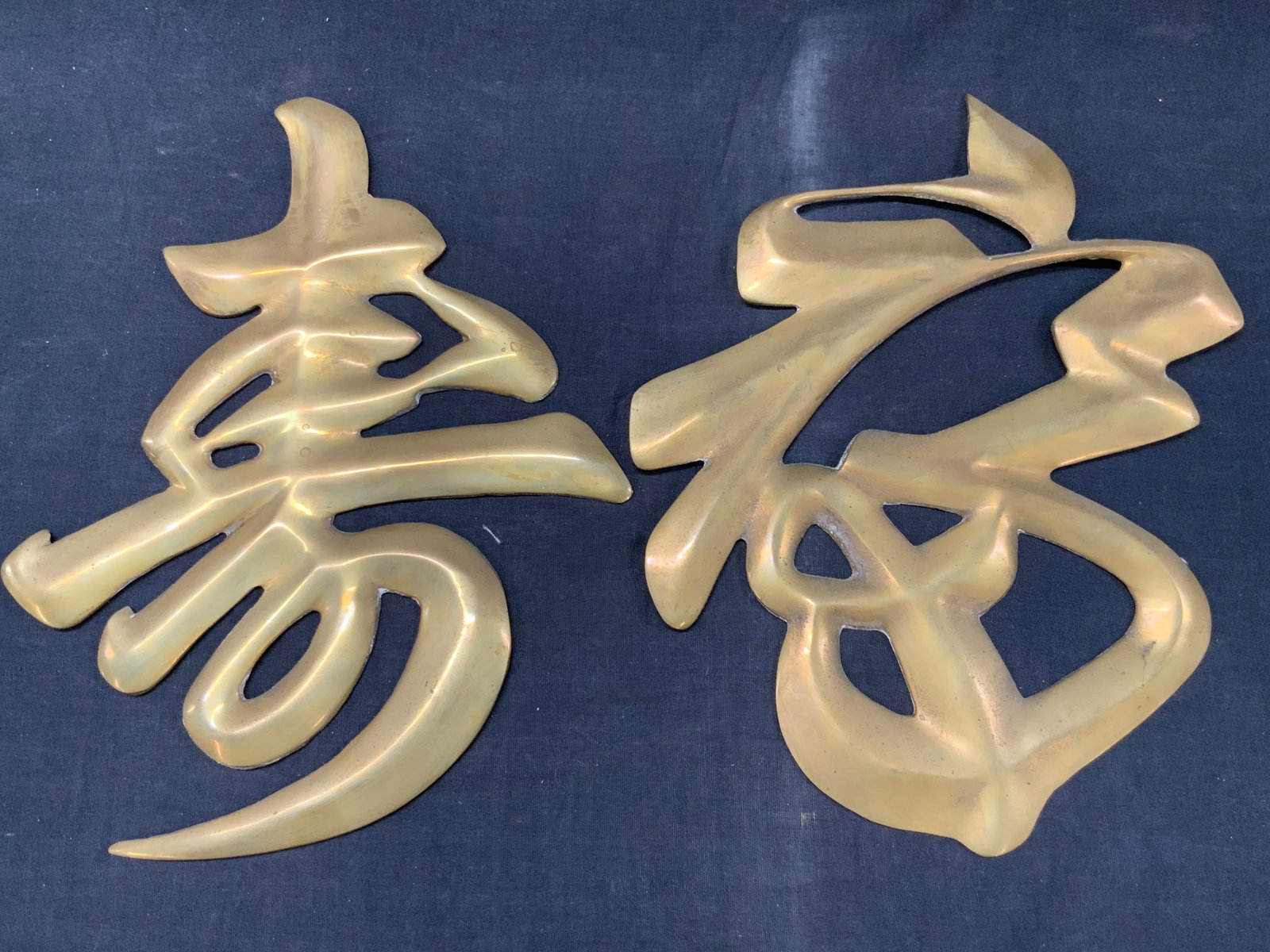 2 Gilt Metal Chinese Character Wall Ornaments: Lot of 2 Gilt metal wall ornaments in Chinese or Japanese kanji characters. Approx 11 x 8 inches. Moderate wearing to edges of metal and backings. metal ware. Metal works, home decor, Asian decor, Asi