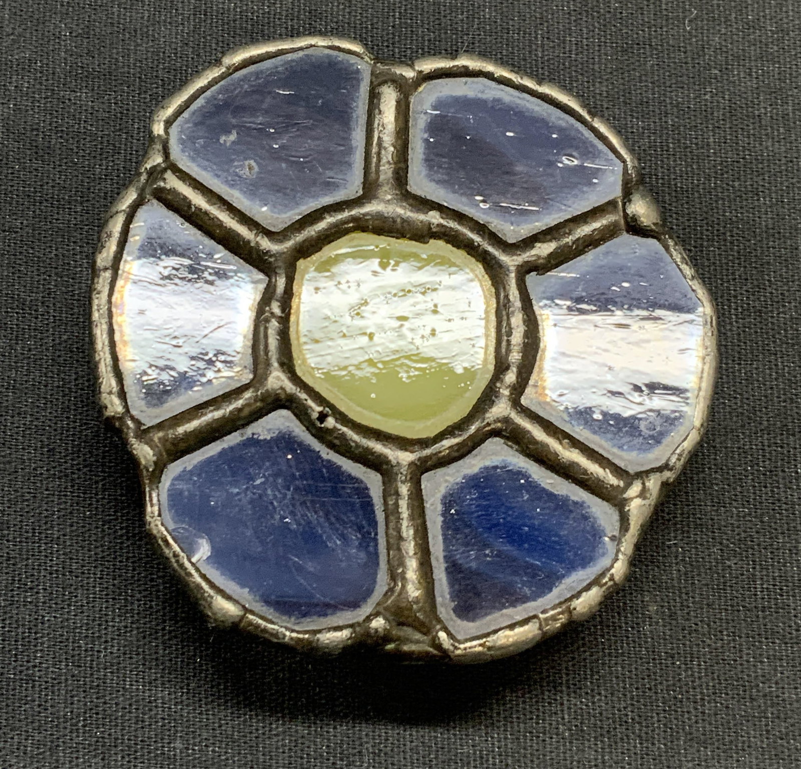 Handmade Stained Glass Flower Belt Buckle: Handmade stained glass belt buckle with flower motif in yellow and blue. Measures approx. 2.5 inches wide. Some surface wear including scratching observed. Belt buckle, flower belt buckle, stained gla