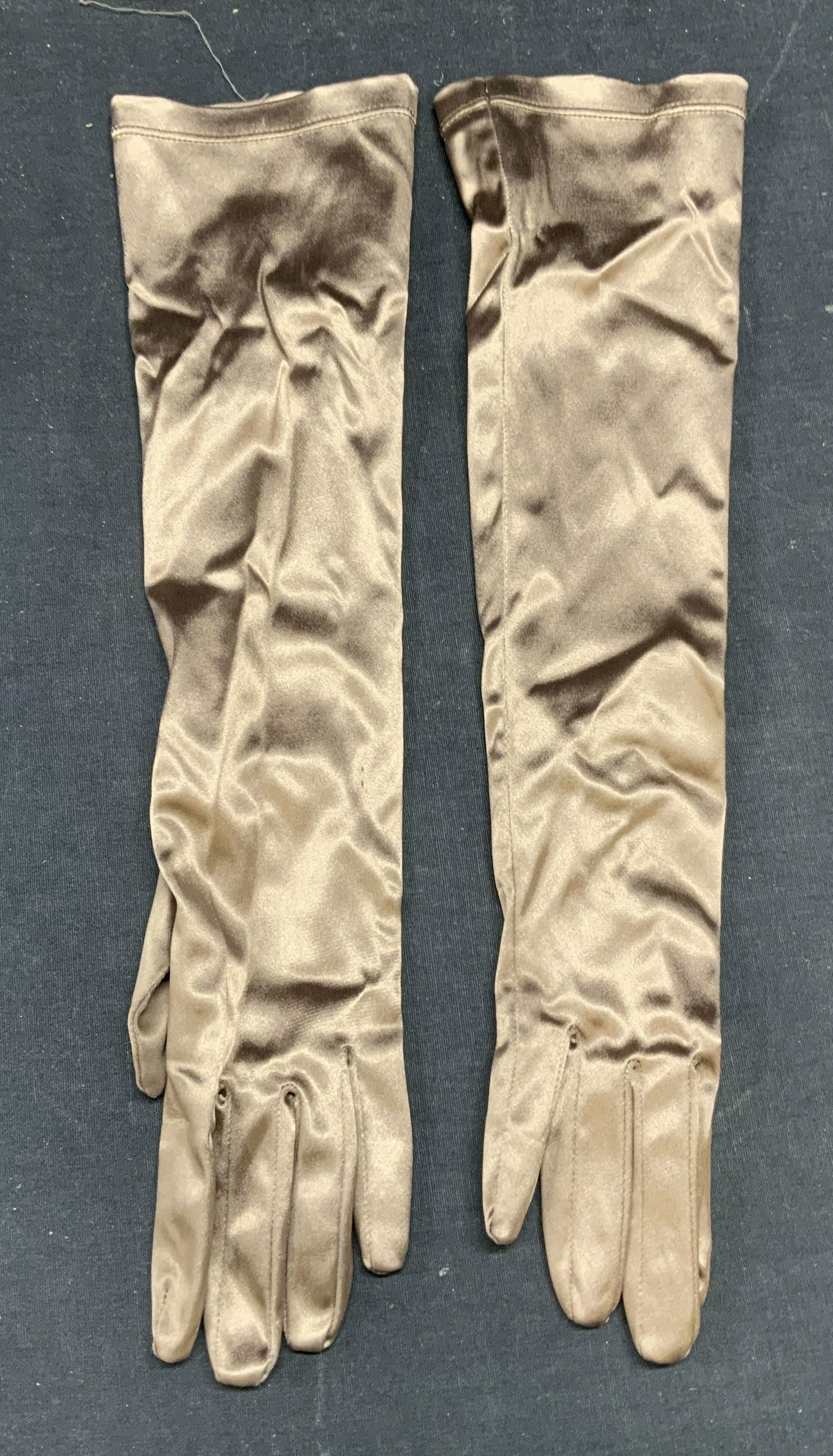 Prada Long Brown Satin Gloves, Italy: Prada long brown satin gloves. Made in Italy. Signed to interior. Measure approx. 15.5 inches long. Synthetic blend. Material has some stretch. Some wear to material including pulling observed. Prada,