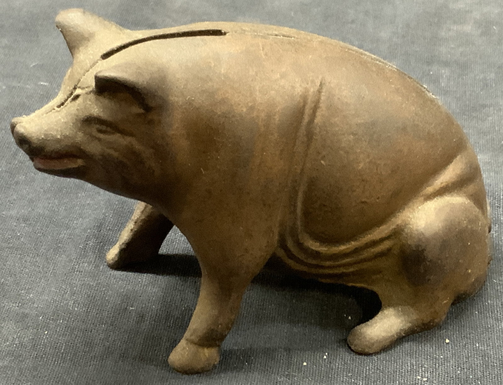 Vtg Cast Iron Pig Coin Bank: Vintage cast iron pink coin bank, resembling a sitting pig with a coin slot on the back of the pig. Approx 3 inches tall and 5 inches long Moderate discoloration to surface of the iron and wearing due