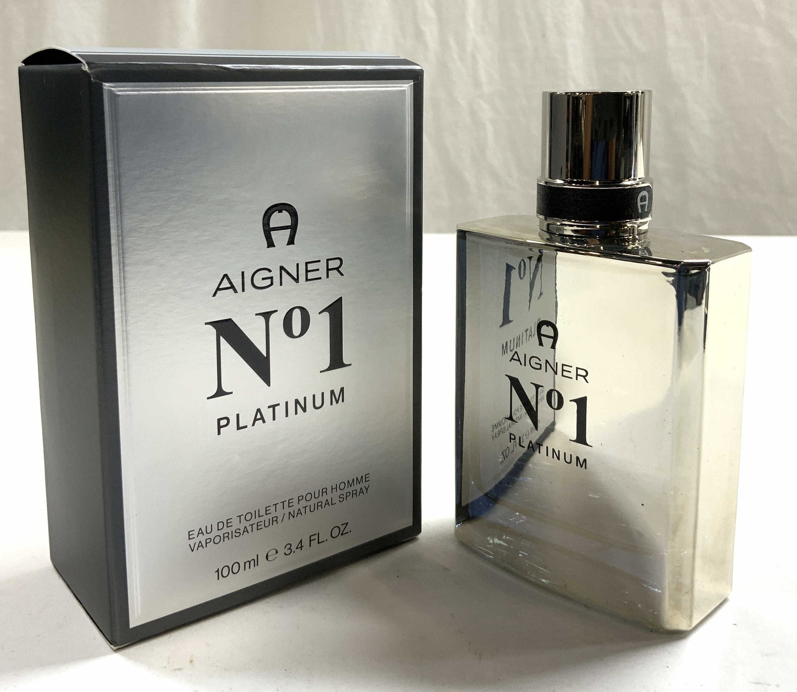 AIGNER NO 1 Platinum EDT 3.4 Fl Oz W Box: Bottle and box reads AIGNER NO 1 Platinum Box is silver toned, and dark slate toned with black toned lettering. Bottle has silver toned cap, appears to be metal. Fragrance has an Eau De Toilette Conce
