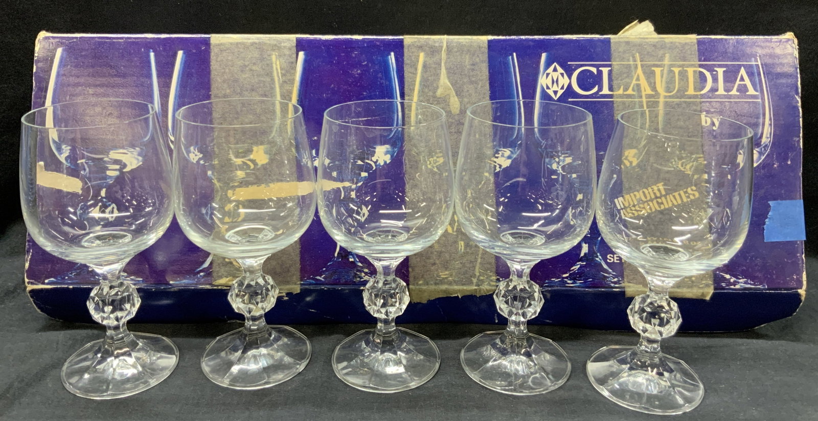 Set 5 Claudia Crystal Wine Glasses Org. Box: Set of 5 crystal wine glasses with faceted orbs on stems. Comes with blue toned box marked Claudia. Glasses measure 6 inches tall. Box measures 18 x 6 inches. Evident wearing to boxes and minor wearin
