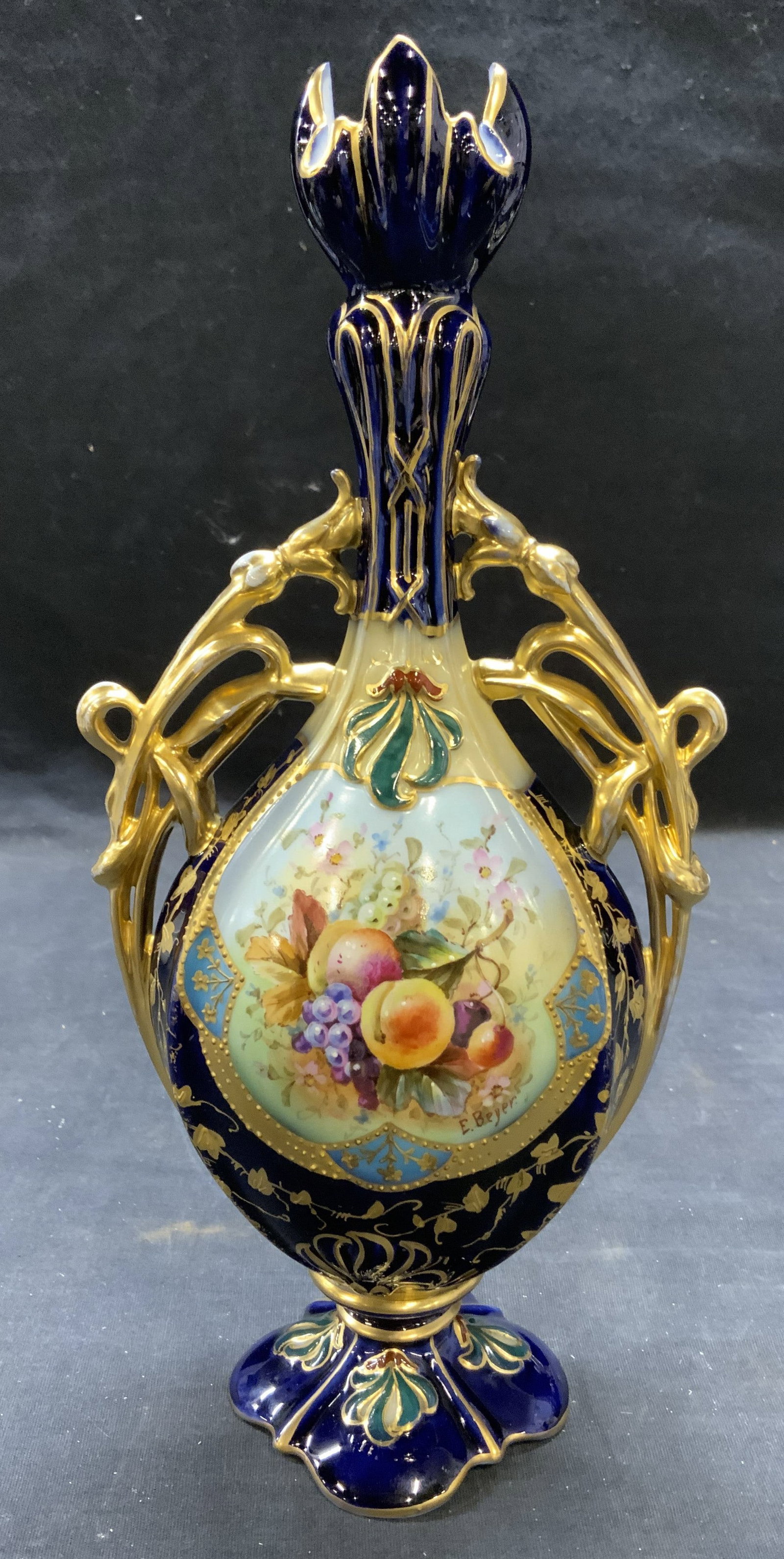 Hallmarked Antique Gilt Porcelain Fruit Urn: Hallmarked antique porcelain urn in cobalt blue with gilt decoration and hand painted fruit motif. Hallmarked to underside. Measure approx. 5 x 3 x 10.25 inches. Some surface wear including scratching