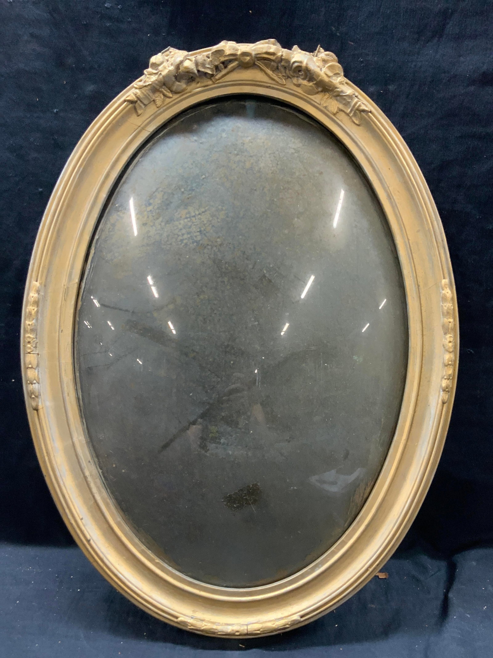 Gilt French Style Wooden Domes Glass Frame: Wooden frame with domes glass. Oval in shape with raised motifs of ribbons and leaves on edges, approx 23 x 17 inches window measures 16 x 13 inches. Moderate wearing to gilt and cracking to wooden fr