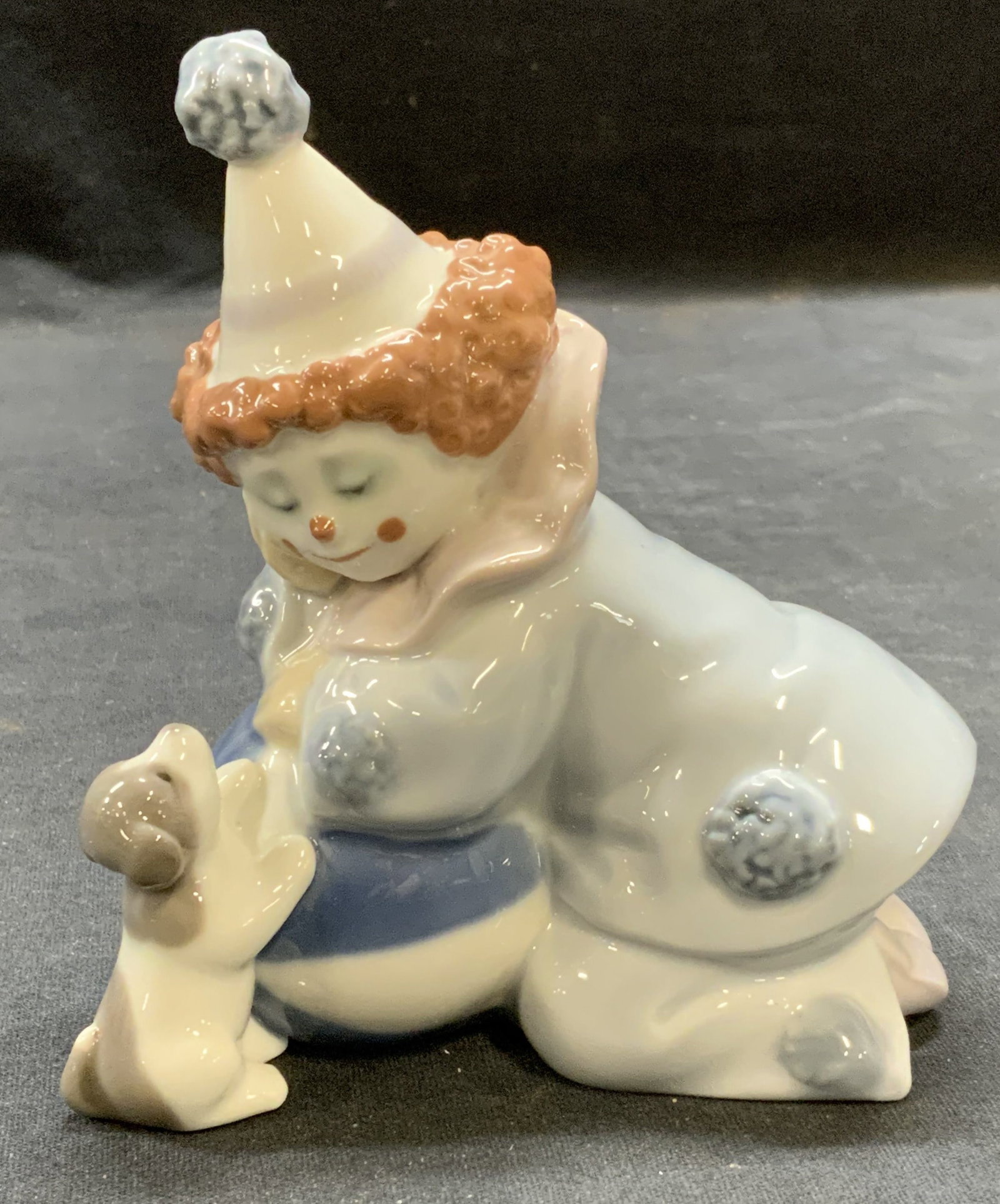 Lladro Porcelain Clown Child Figural, Spain: Lladro porcelain clown child figural in blue. Trademarked to underside. Made in Spain. Measures approx. 4.25 x 2.25 x 4.75 inches. Some surface wear consistent with exposure. Lladro, Lladro figural, L