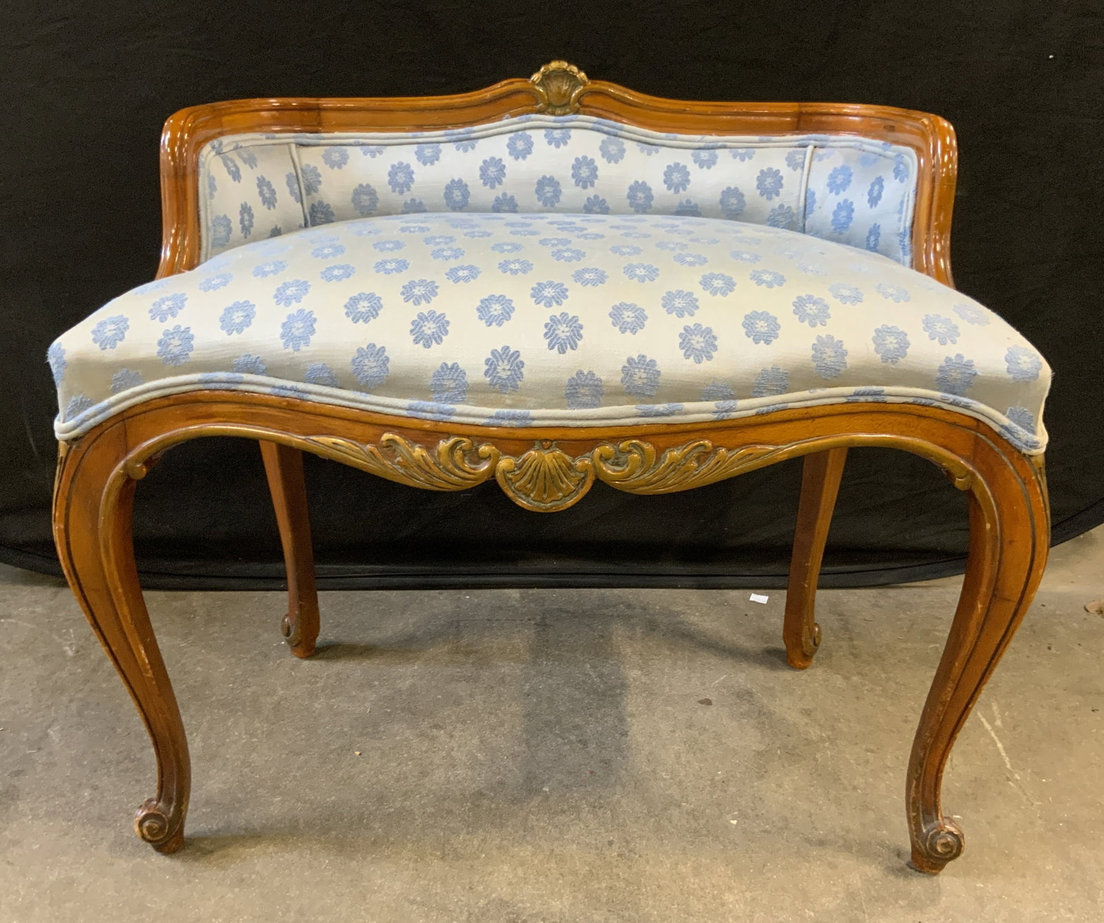 EL KAY UPH & DECORATING Wooden Vanity Bench: Tag reads EL KAY UPHOLSTERING & DECORATING. Bench has beige toned carved wooden frame. Upholstery has double welting at edges. Piece has floral pattern detailed upholstery. Bench measures approx 28 in