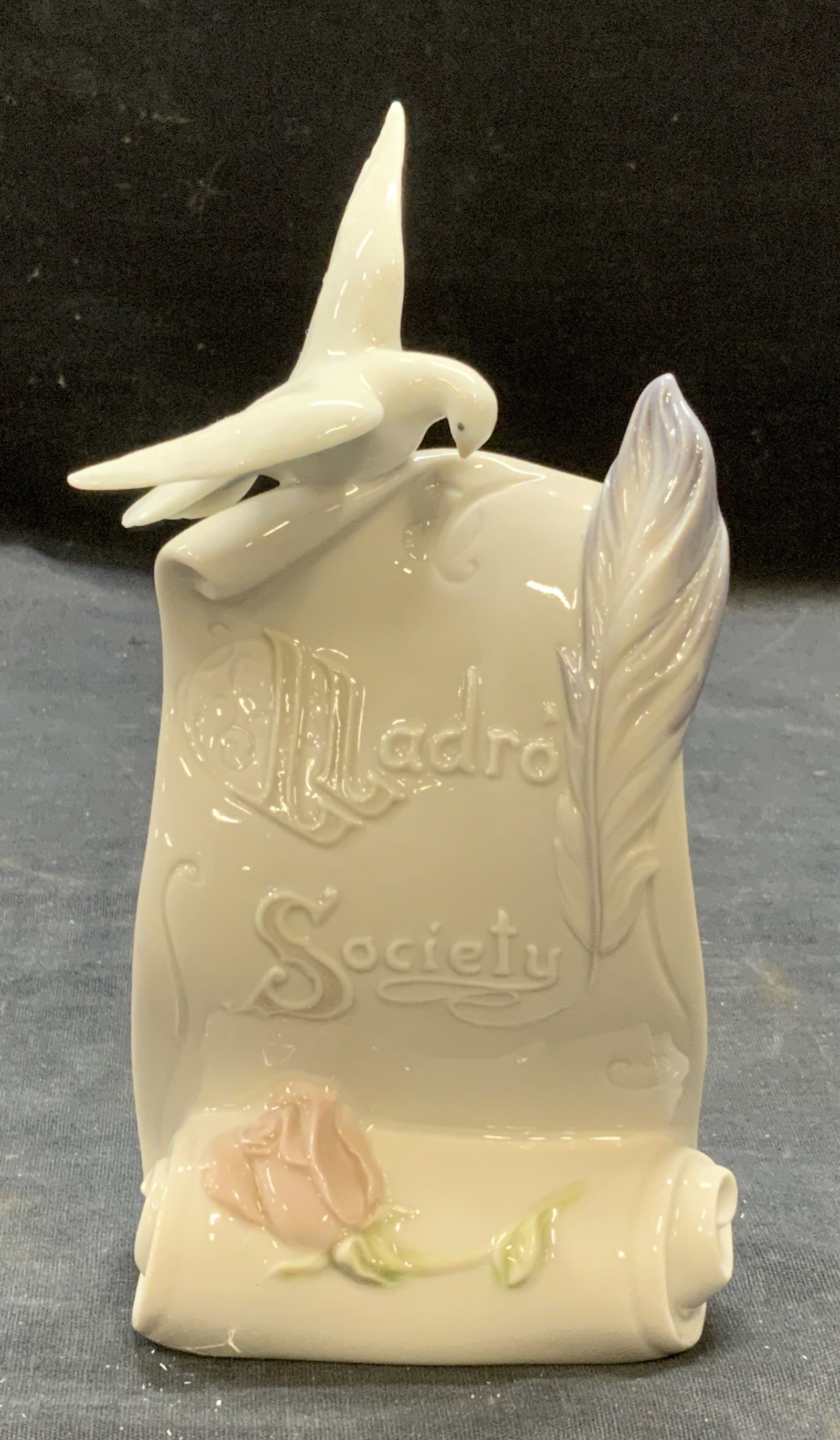 Lladro Society Porc Scroll&Dove Figural Spain W Bx: Lladro Society Art Brings Us Together porcelain scroll and dove figural with flower and quill motif. Trademarked to underside. Made in Spain. Includes original box. Measures approx. 3.5 inches wide an