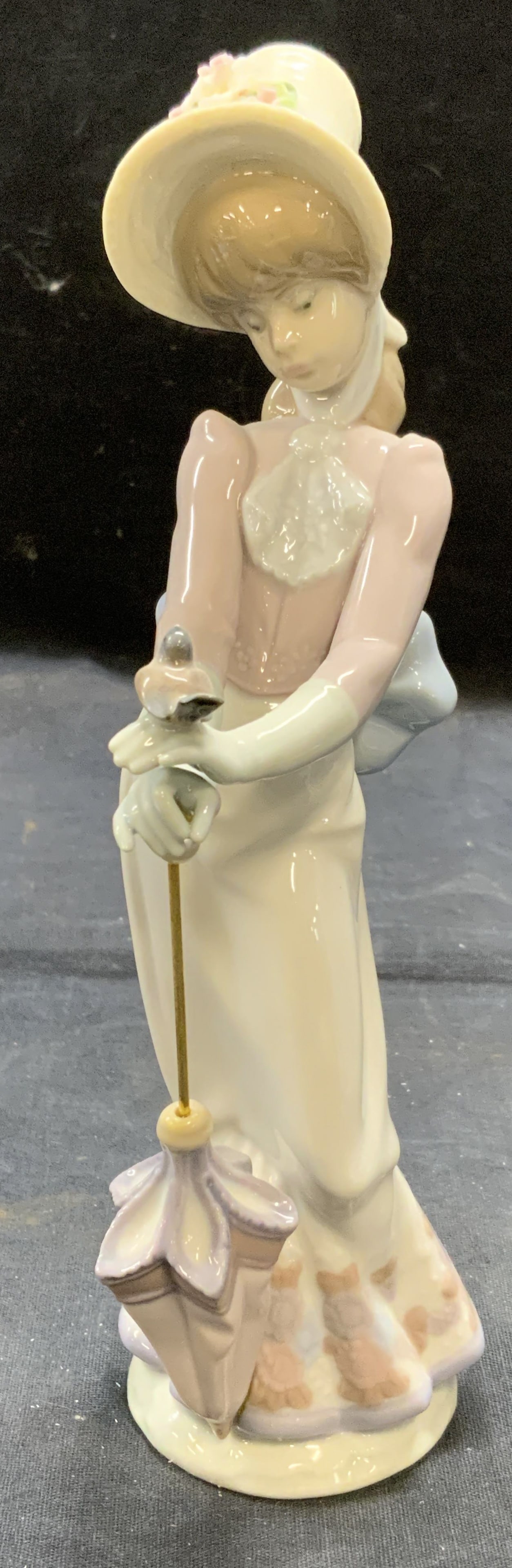 Lladro Porc Garden Song Woman Figural Spain W Box: Lladro porcelain Harden Song woman with parasol figural. Trademarked to underside. Made in Spain. Signed to underside. Includes original box. Measures approx. 2.5 inches wide and 8.5 inches tall. Some