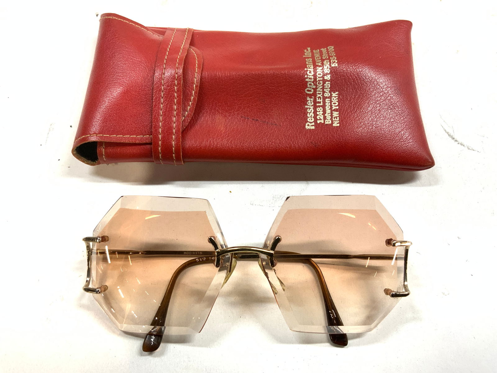 Octagonal Lens Sunglasses & Leather Case: Lot includes 1 pair of sunglasses and 1 red toned leather eyeglass case pouch. Sunglasses have octagonal shaped lenses. Shades measure approximately 5.5 inches wide 5.25 inches deep 2.25 inches tall.