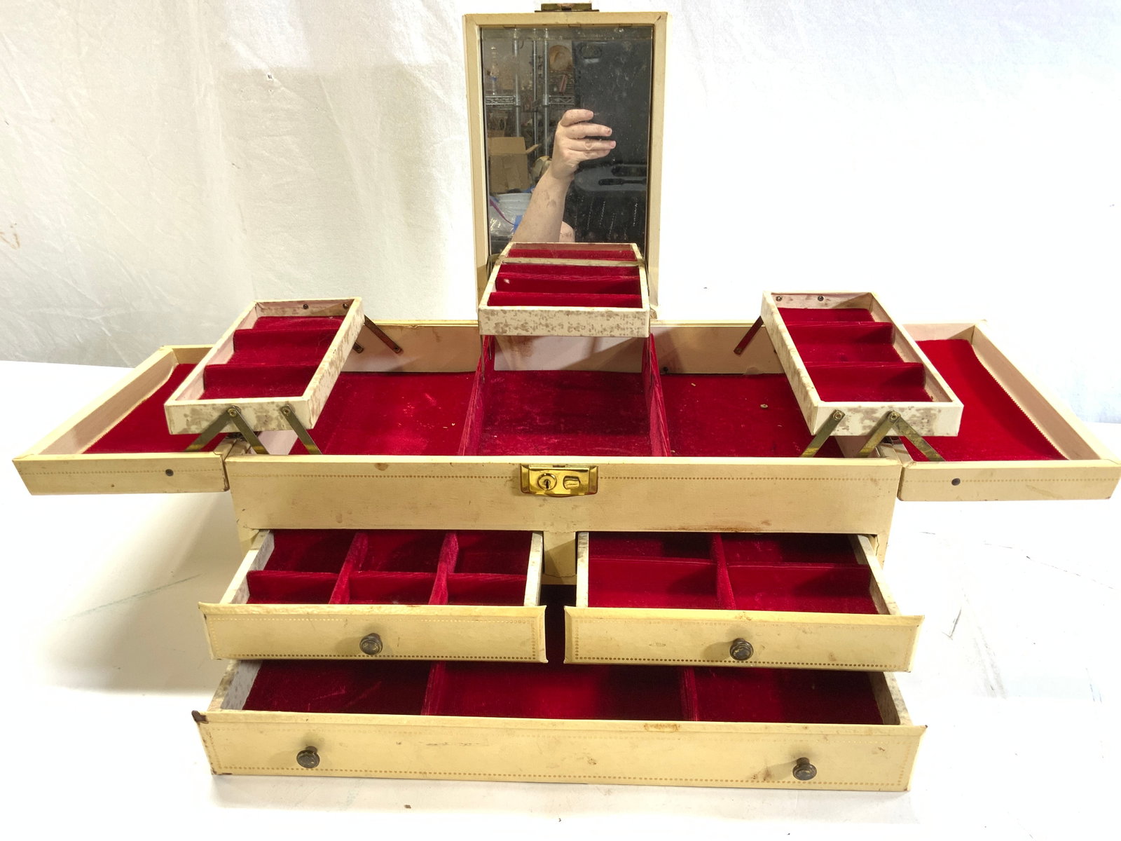Vintage Dresser Top Jewelry Box: Vintage jewelry box with lift up mirror, red velvet covered interior compartments/ drawers. Exterior faux leather. Has discoloration and 1 hinge unattached. Press button to the right to lift up center