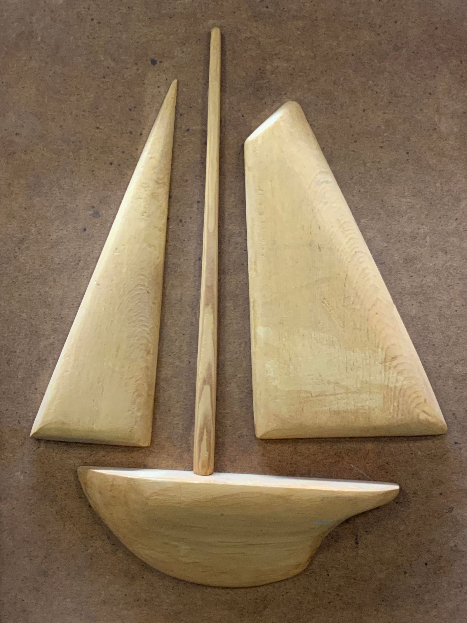 Carved Wooden Sail Boat Wall Panel: Carved wooden wall panel depicting a raised image of a sail boat also made of tan toned wooden. Framed in wooden frame approx 16 x 13 inches. Moderate wearing to edges of paneling and to wood througho