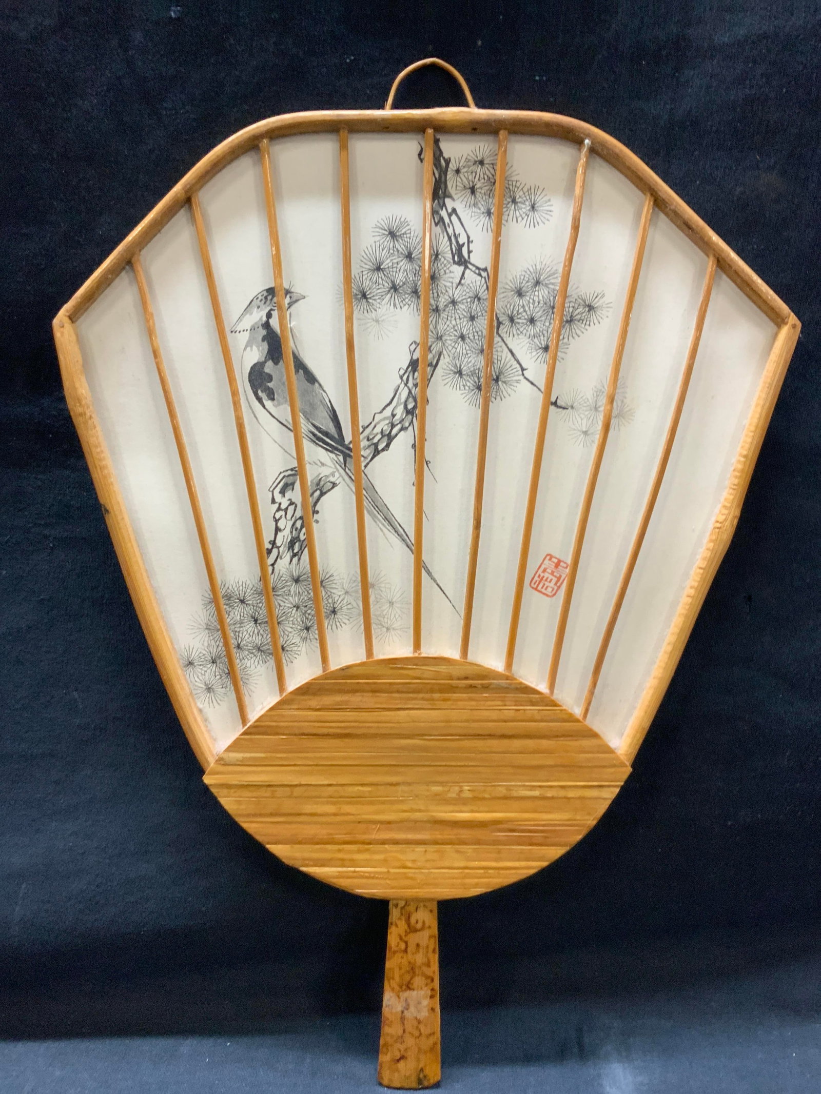 Stamped Asian Bamboo Fan: Stamped in red, adorn with a motif of a perched bird on a branch within a wooden frame with handle. Approx 16 x 11 inches. Moderate wearing to wood and to artwork. Home decor, Asian decor, wall art, a