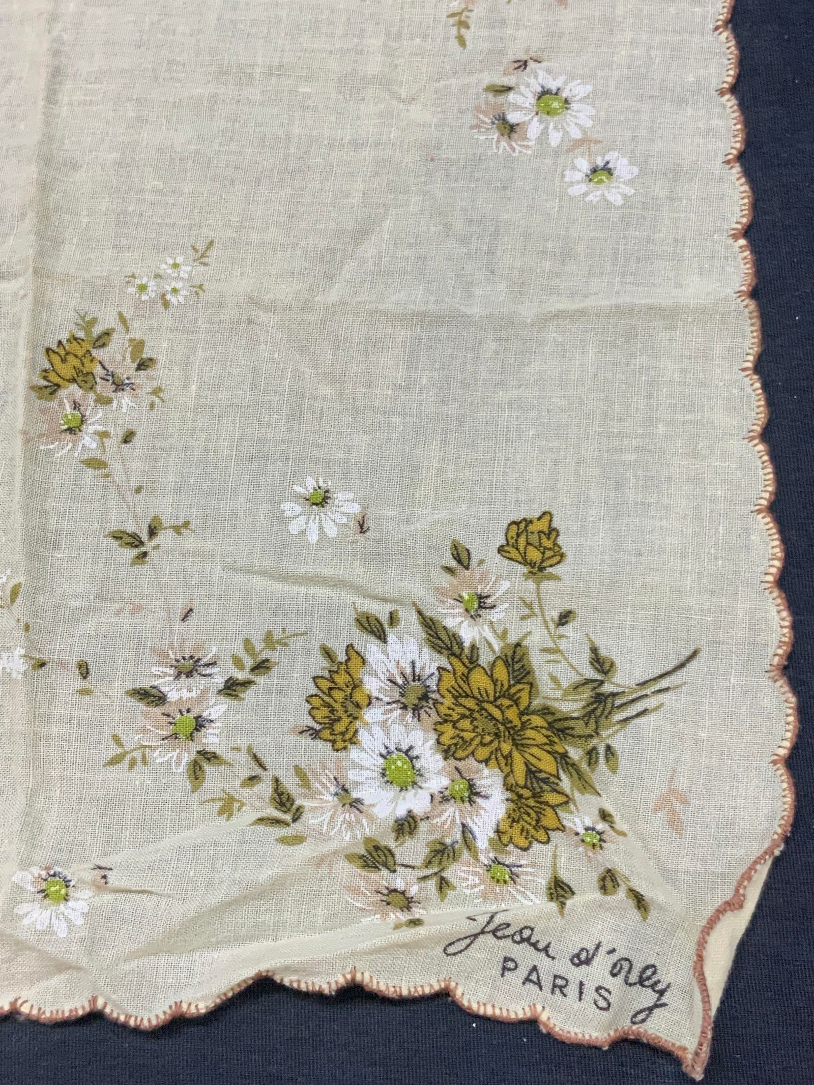 Vtg Jean Ol Orly Floral Linen Handkerchief, Paris: Vintage handkerchief, possibly made of cotton or linen with white and yellow flowers on edges and corners and scalloped edges. Marked on corners with a name, Paris. Approx, 11 x 11 inches Moderate wea