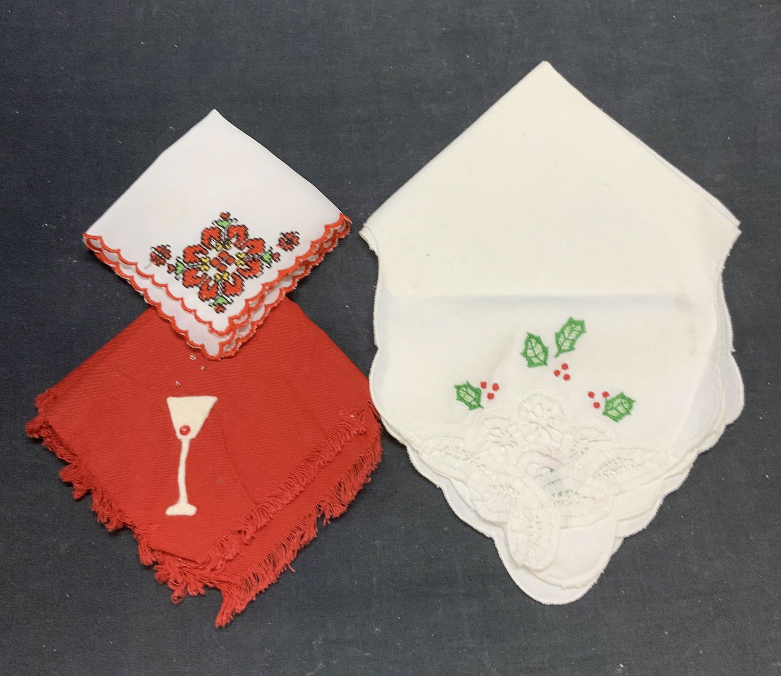 Lot 3 Handkerchief, Cocktail Napkin, Table Linen: White and red floral motif handkerchief. Synthetic material. Red martini glass motif cocktail napkin. Feel like cotton. White holly motif and lace table linen. Feels like cotton. Largest piece measure