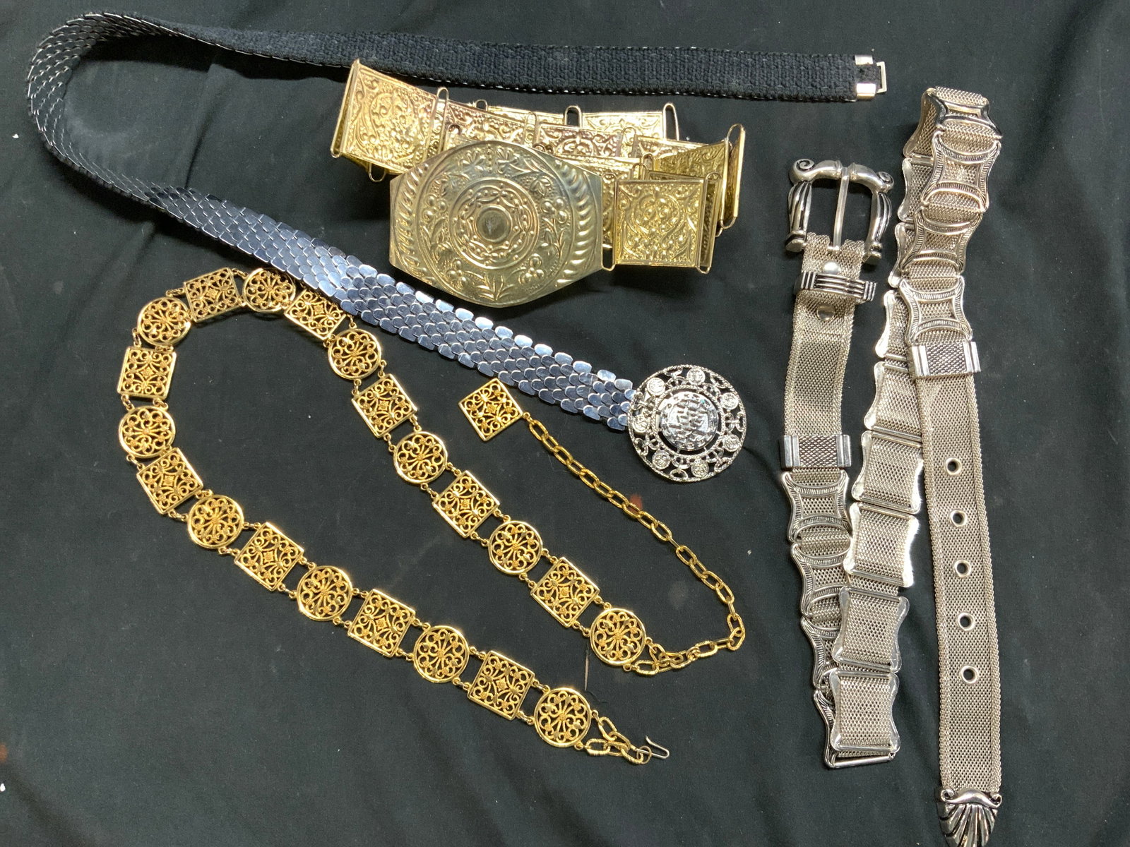 Lot 4 Vtg Fashion Metal Belts: Vintage ladies belts. Metal belts, some heavy, others lightweight. Gold tone repousse metal belt, square links, lightweight. Possibly aluminum. Hook closure 36 in. Waist, 1.25 in. Wide. Large statemen
