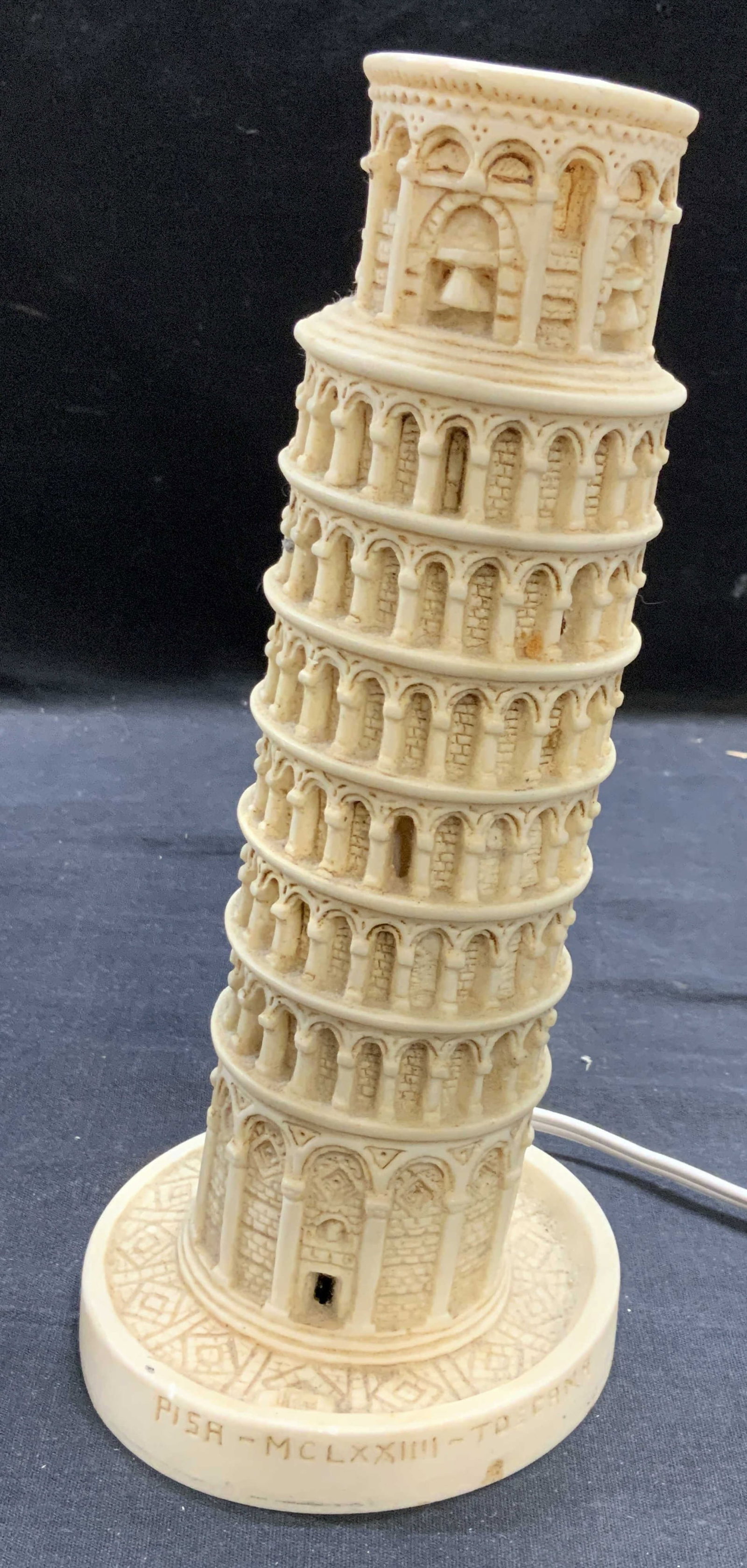 Leaning Tower of Pisa Table Lamp: Leaning Tower of Pisa table lamp. Raised surface. Composite material. Measures approx. 4.25 x 9.5 inches. Some surface wear including scratching observed. Not tested for function. Lighting, table lamp