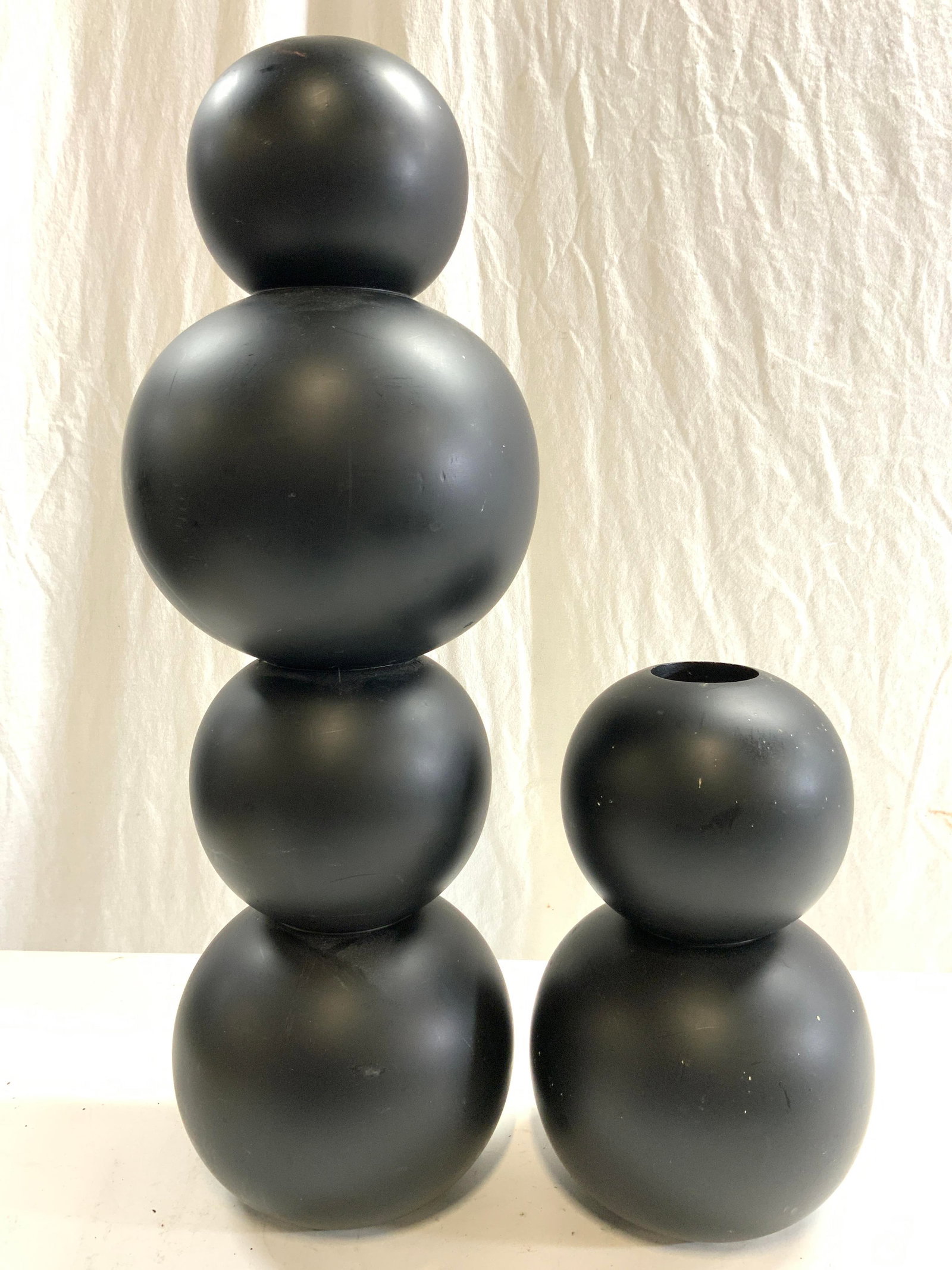 Lot 2 Comp Stacked Orb Vases Vessels Black: Lot includes 2 vases. Each have stacked orb form. One is 2 orbs high, the other 4 orbs high. Each vessel is black toned. Vases appear to be composite Largest vase measures approximately 22 inches tall