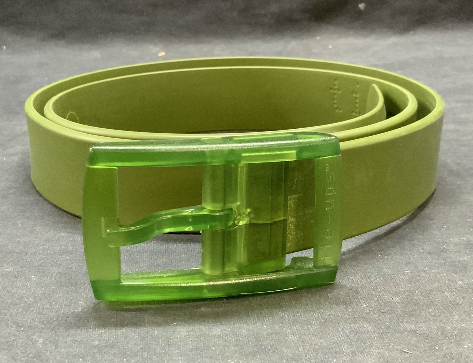 Tie Ups Green Recyclable Belt, Italy: Tie Ups solid green belt. Composed of recyclable material. Made in Italy. Measures approx. 47 inches long. Some wear to material consistent with exposure. Tie ups, tie ups belt, ladies designer belt, 