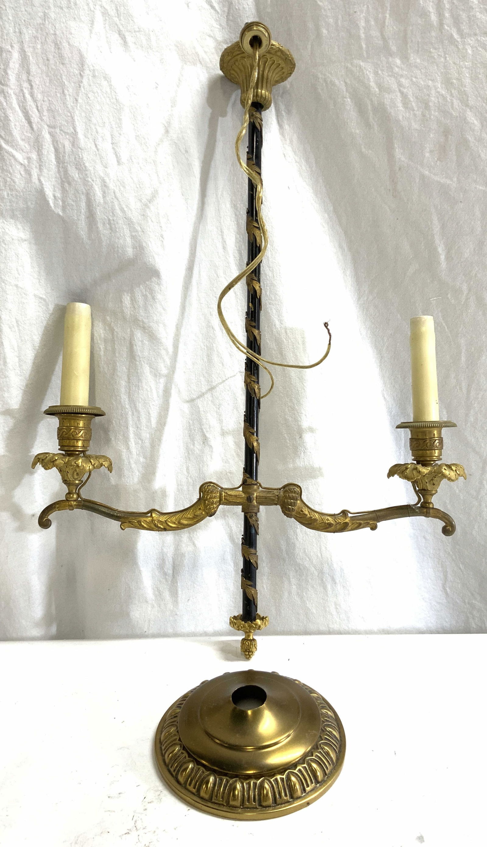 Gilt Metal Ornate 2 Arm Chandelier: Chandelier appears to be gilt metal & iron. Piece has 2 arms each with scroll & leaf detail. Each arm has candlestick style bulb sockets at ends, piece is black and gold toned. Includes gold toned bru